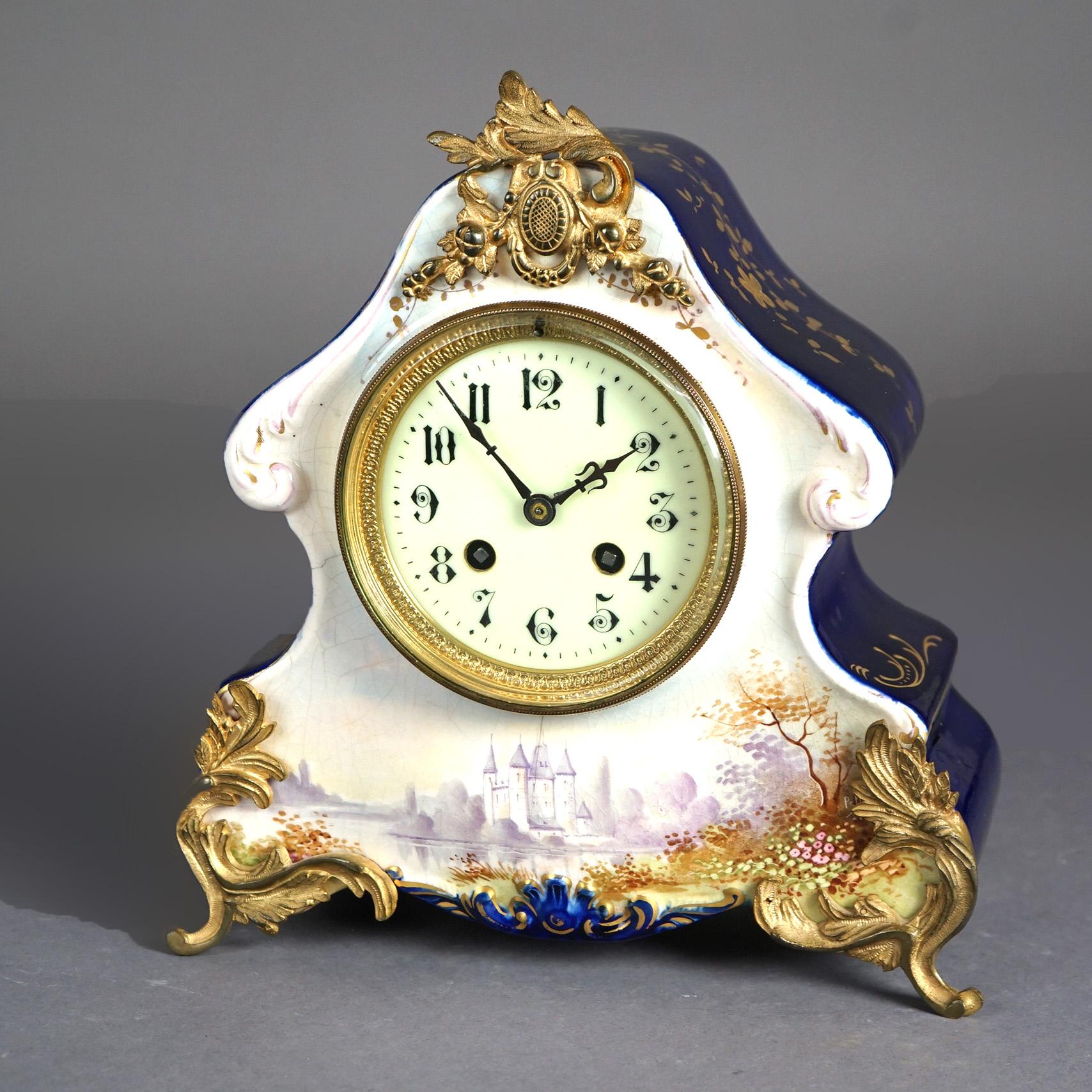 An antique French Rococo mantel clock offers porcelain construction with hand painted castle lake scene and heavily gilt  elements, Made in France, 19th century.

Measures - 10.75