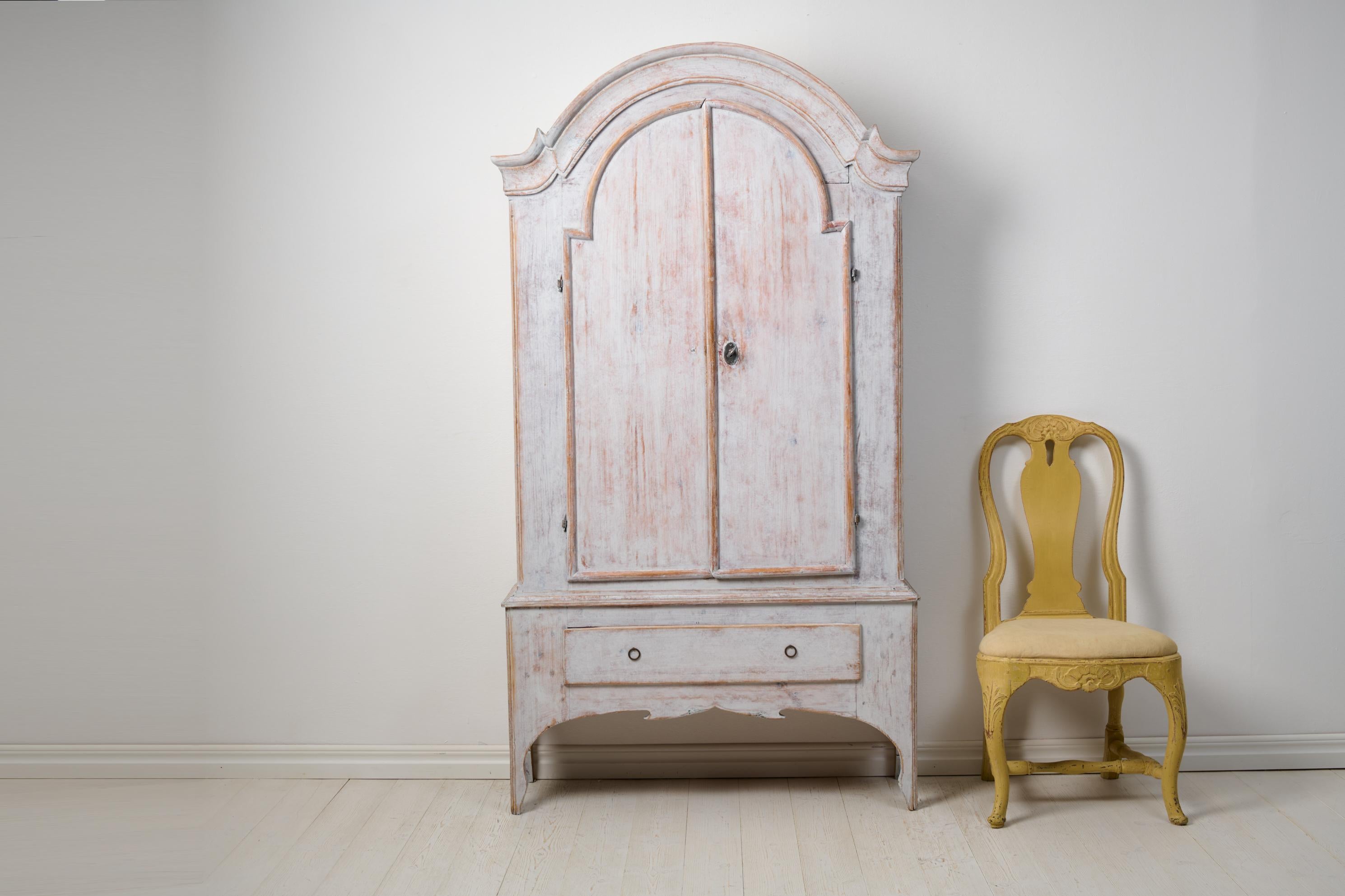 Antique grey rococo cabinet, a genuine rustic Swedish country house furniture. Transform your space with the timeless allure of this Northern Swedish antique rococo cabinet from Jämtland. Handcrafted with precision in solid pine around 1800 to 1820,