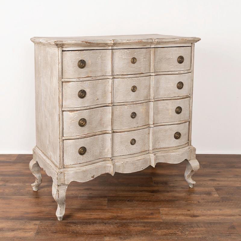 The soft gray painted finish is captivating in this attractive large chest of four drawers resting on curved cabriolet feet. While the paint is newer and professionally applied, it compliments the age, rococo style and serpentine curves of this