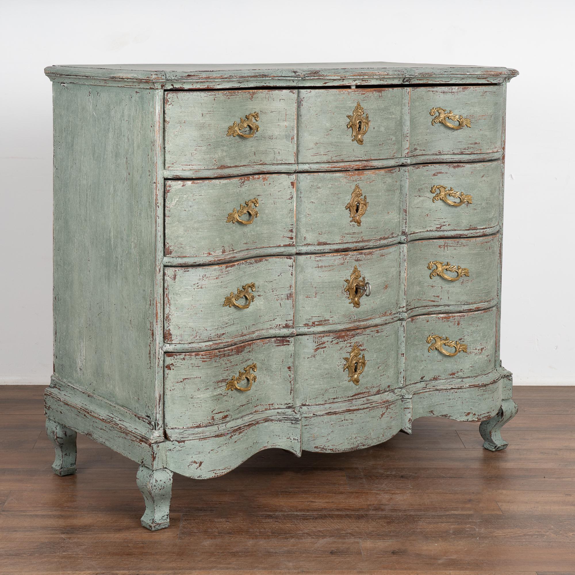 This large antique rococo oak chest of drawers features a serpentine front, brass hardware pulls and rests on cabriolet feet.
It has been given an exceptional new professional seafoam blue layered painted finish and has been lightly distressed,