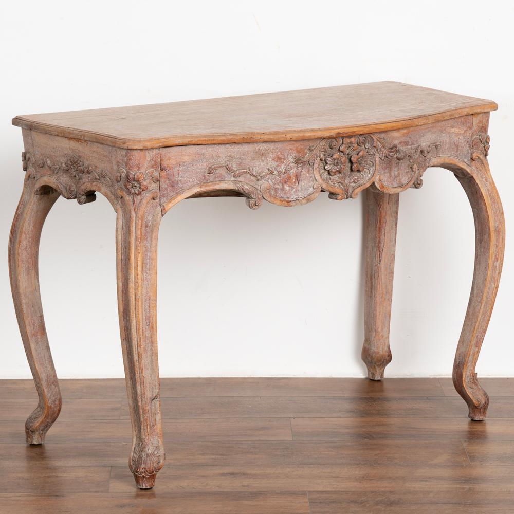 This elegant rococo table has a soft blush finish adding to the romance of the cabriolet legs and carved floral flourishes that embellish this lovely side table. 
The newer, professionally applied layered paint has a soft rose colored palette,