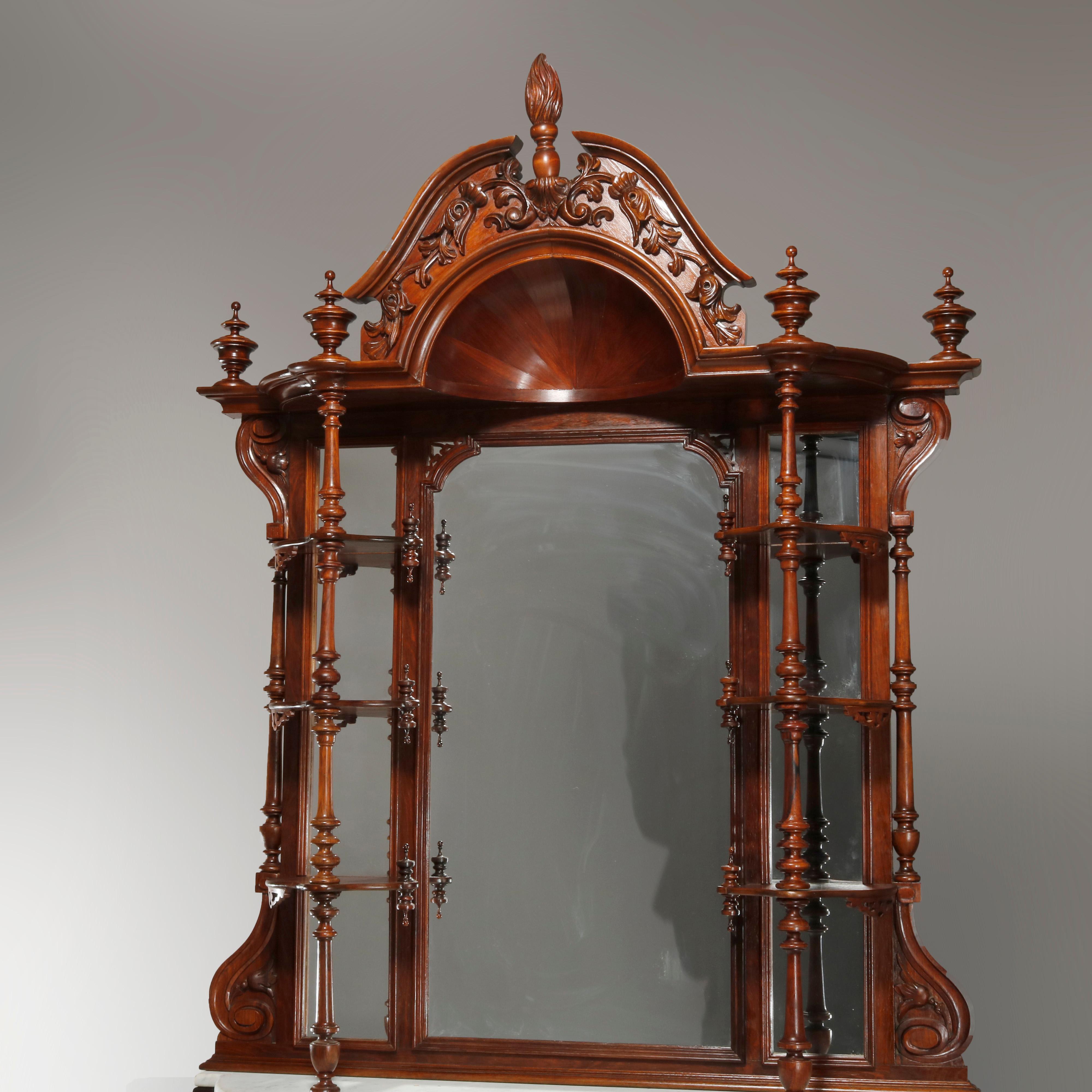 An antique Rococo Revival étagère sideboard offers rosewood construction with broken arch crest having carved foliate elements, central finial and sunburst dome over surmounting mirror with flaking display shelves surmounting case with shaped marble