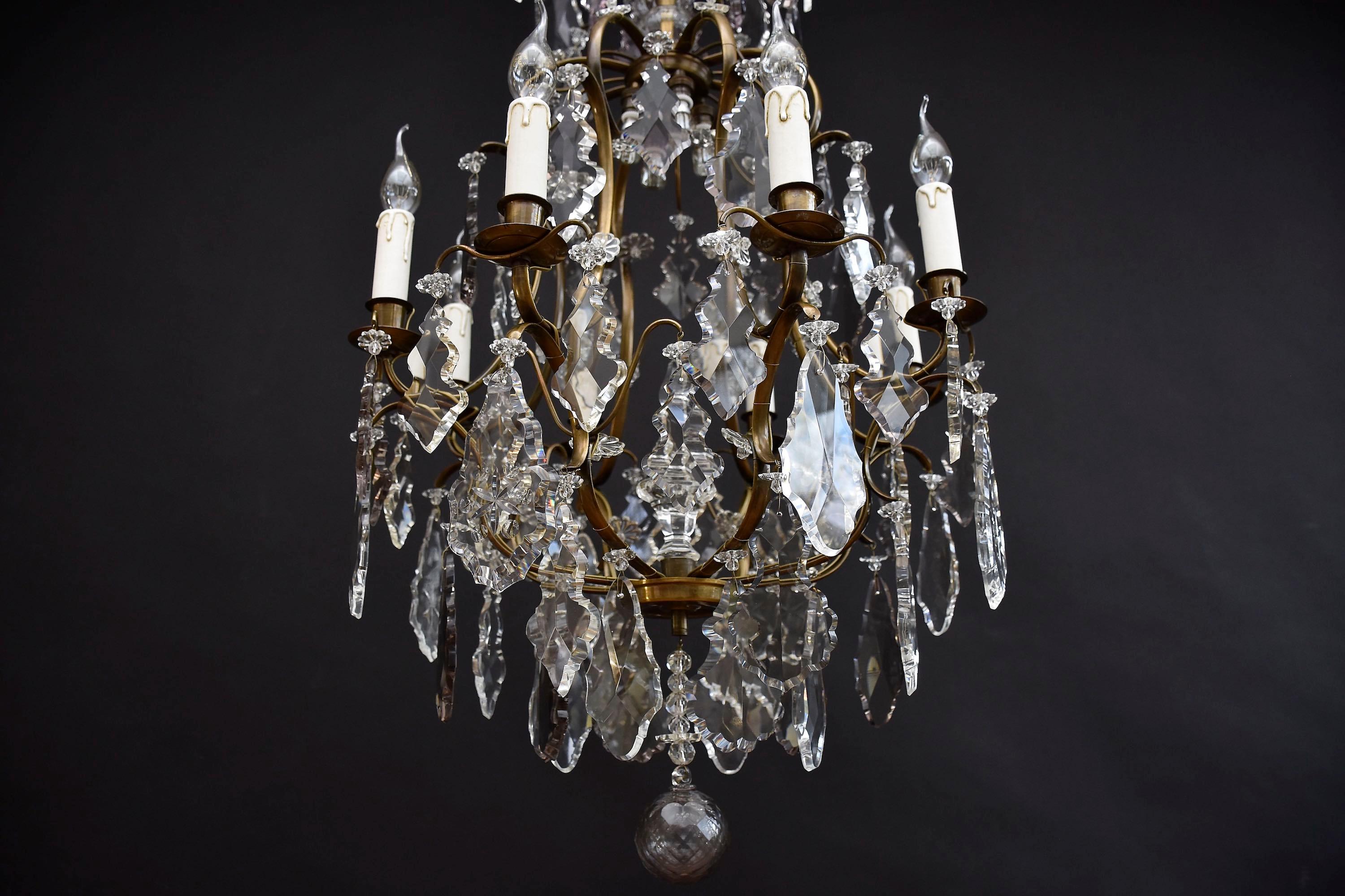 Un elegante lampadario rococò nordeuropeo con 4 piccole luci interne e 8 bracci di candele.
Con una bella patina antica; decorato con diversi grandi pendenti e rosette di fiori in cristallo tagliato originale, di colore chiaro e tenue (ametista