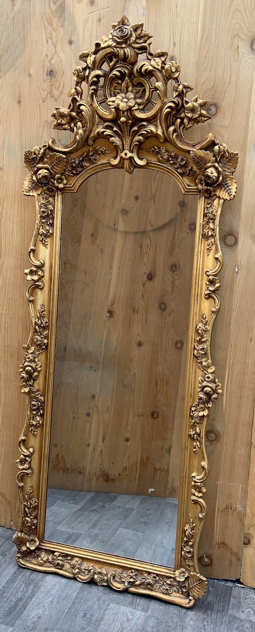 Antique Rococo Style Ornate Carved Floor Wall Mirror 

The Antique Rococo Style Ornate Carved Floor Wall Mirror is an exquisite and generously sized mirror designed in the opulent Rococo style. With a stunning gilt gold finish, this mirror boasts