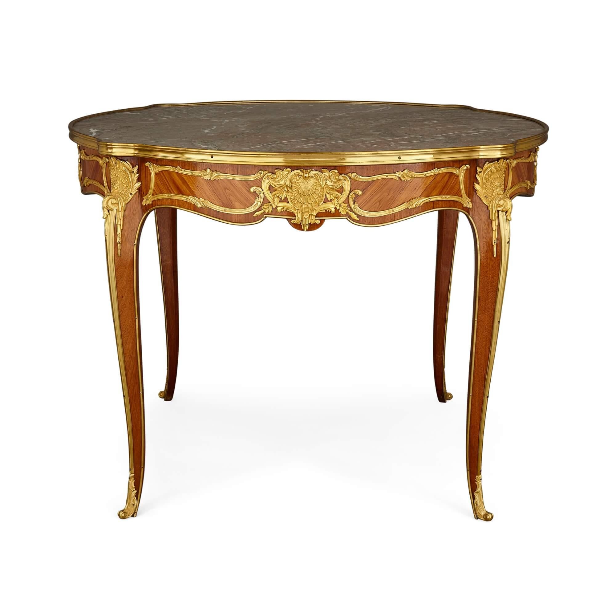 Antique Rococo style rosewood, ormolu and marble centre table.
French, Early 20th century.
Measures: height 76cm, diameter 92 cm.

This expertly crafted rosewood centre table is in the Rococo style. The table features four cabriole legs which