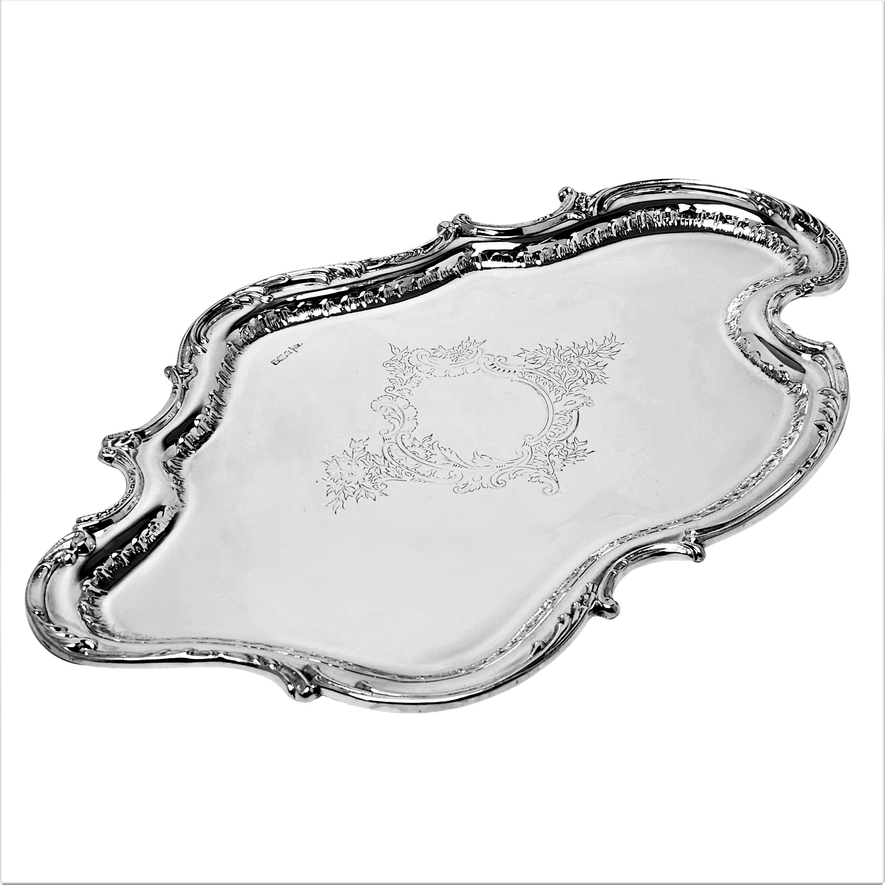 An elegant Antique solid Silver Salver with an unusual asymmetrical Rococo inspired cartouche shape. The Rim of the Tray is embellished with a chased border and an ornate engraved central cartouche. 

Made in Sheffield, England in 1902 by Walker &