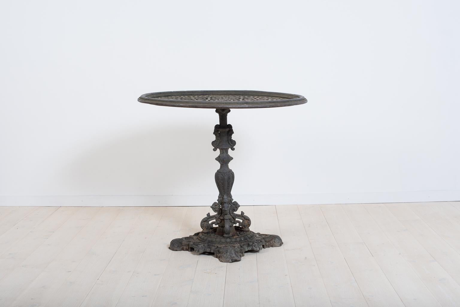 Large antique garden table from Sweden. The table is from the late 1800s and in the rococo revival style. Made in solid cast iron. The foot is stead and solid and intricately decorated. Attractive and authentic patina.
   