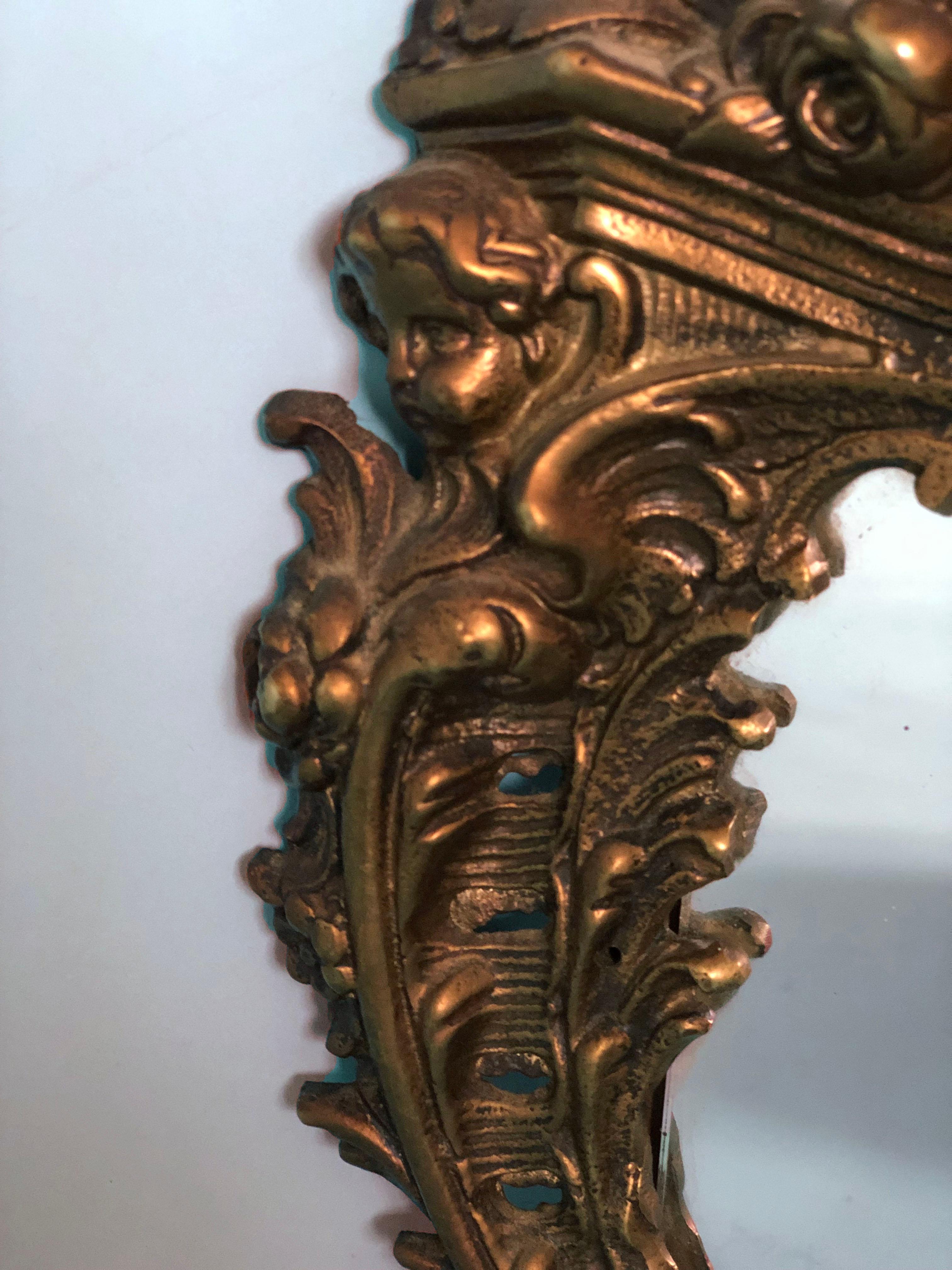 A richly detailed gold table mirror in the rococo style. This antique bronze mirror standing on 2 legs has a cherub head on the side.

Beautifully weathered mirror In good condition. France, Late 19th Century.

Object: Mirror
Designer:
