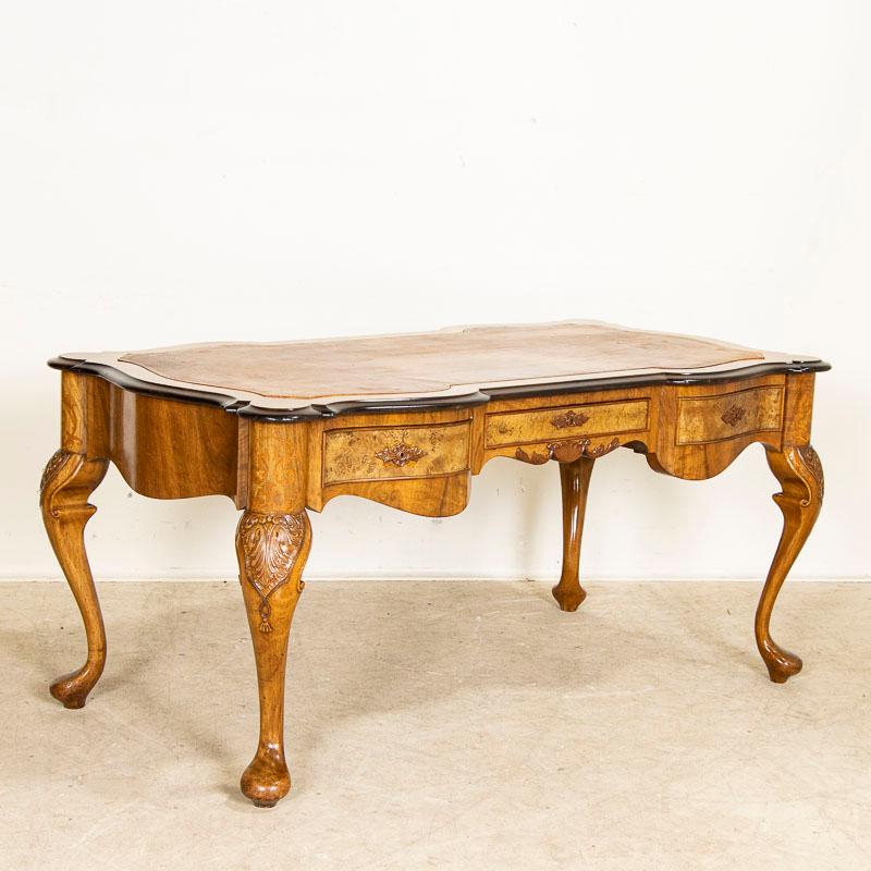 This antique desk is visually stunning due to the exceptional Danish craftsmanship and rococo (2nd period) style. The superb details include 3 birch veneer drawers, cabriole legs with inlaid marquetry, carving, and a sculpted desk top with scalloped