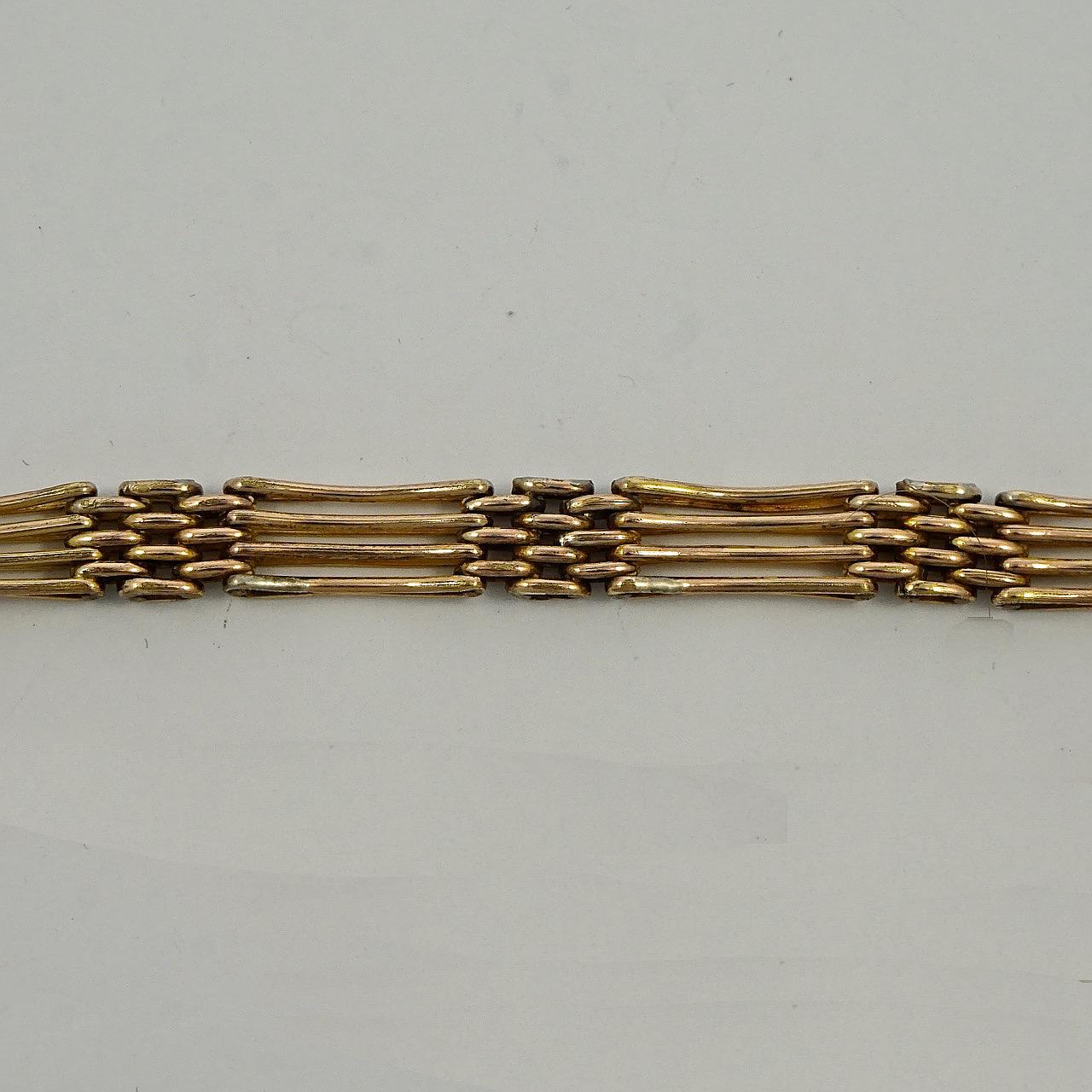 Lovely antique rolled rose gold gate link bracelet with a safety chain, featuring curved four bar links and a heart clasp. Measuring length 20.3cm / 8 inches by width 6.5mm / .25 inch. The bracelet has wear to the gold, and the heart has scratching.
