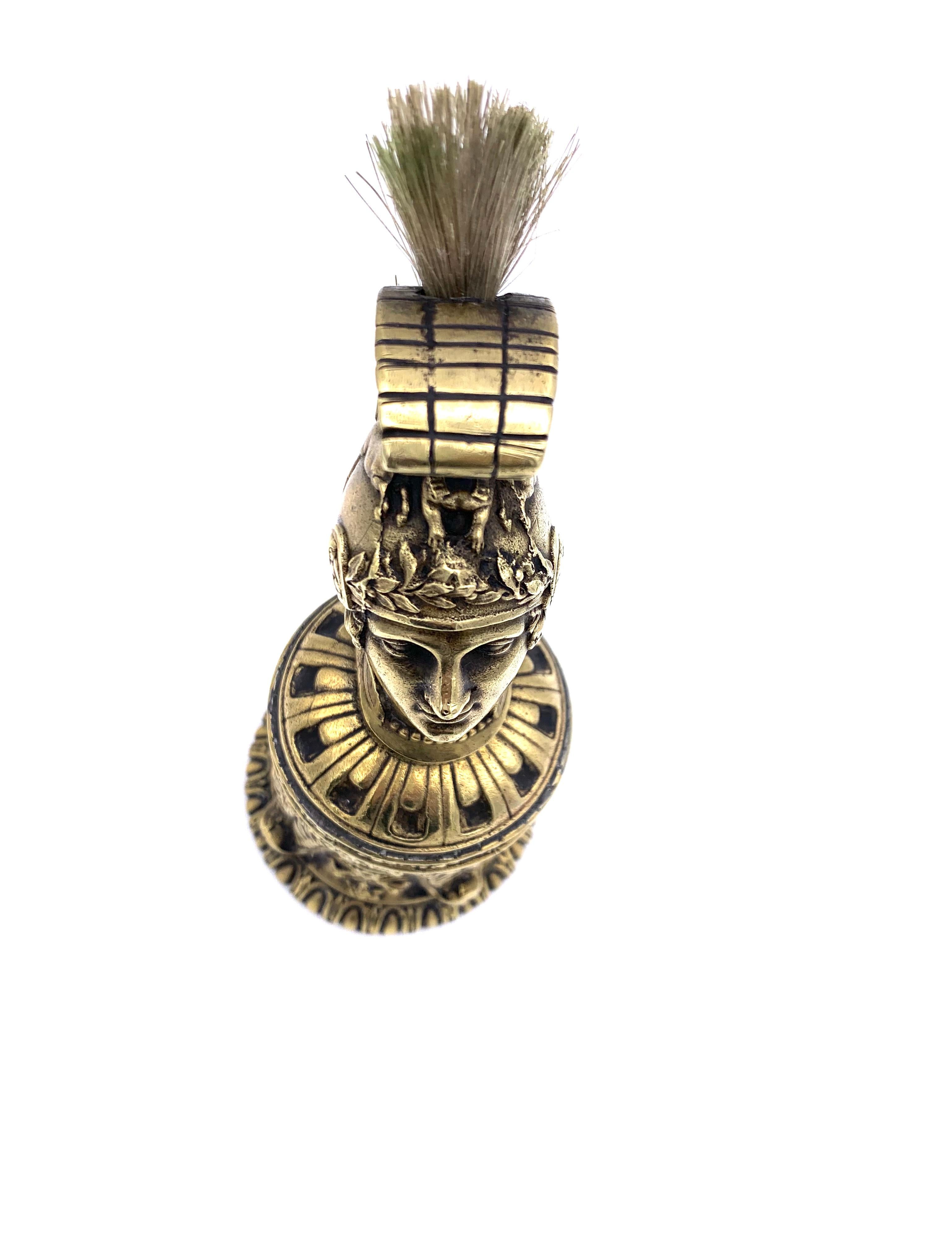 Highly unusual brush for cleaning fountain pens in the shape of a Roman charioteer. This outstanding object doubles also as a table bell with a doublefaced  clapper. The bell is made out of cast bronze 
with very fine detailing.
This object is a