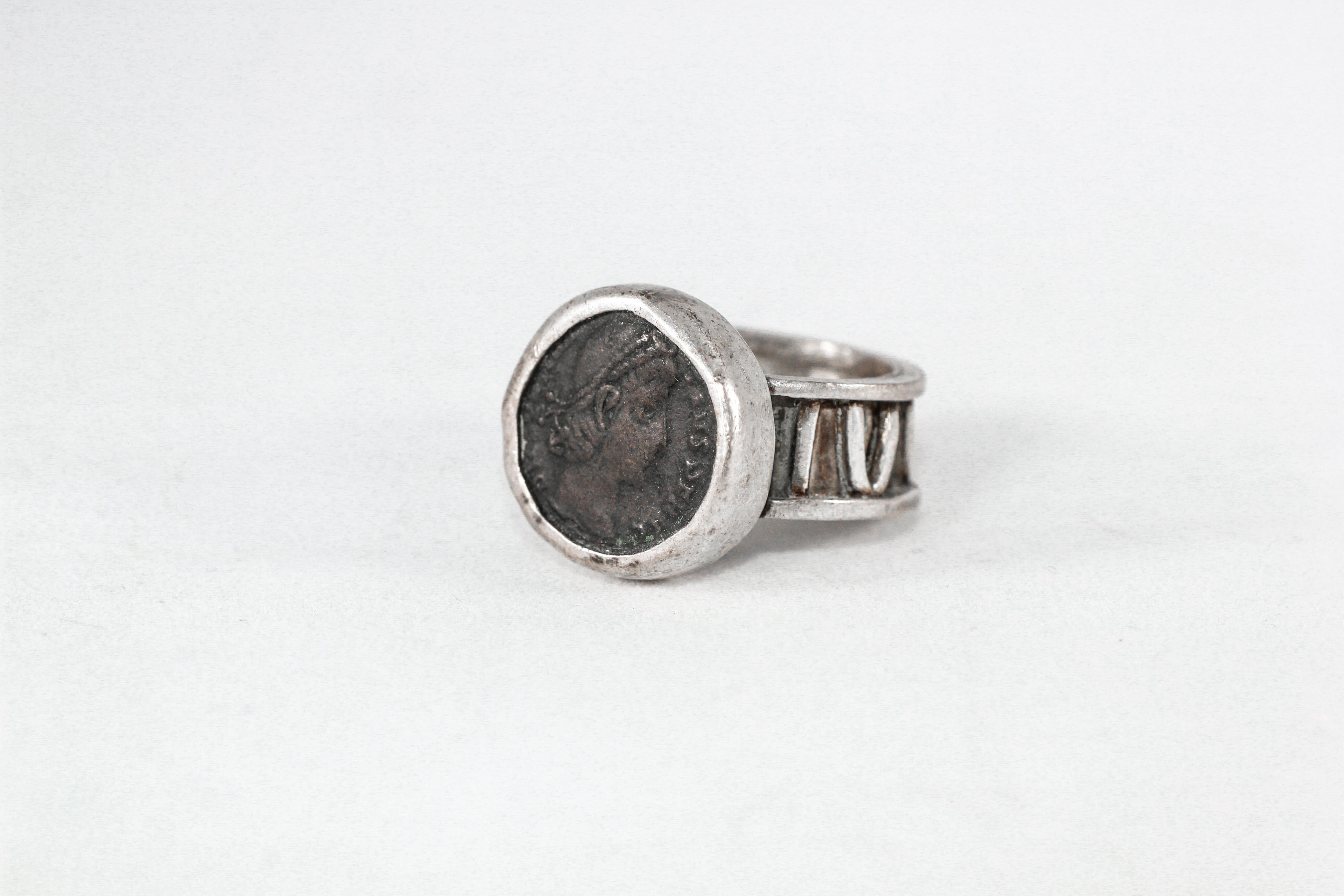 Roman Coin Ring. In this custom designed fine silver signet ring, a bronze Roman Coin is set in a bezel. The shank displays a year in Roman numerals. 

The inspiration for this ring comes from subjectivity and symbolism of Modernist Art. The idea