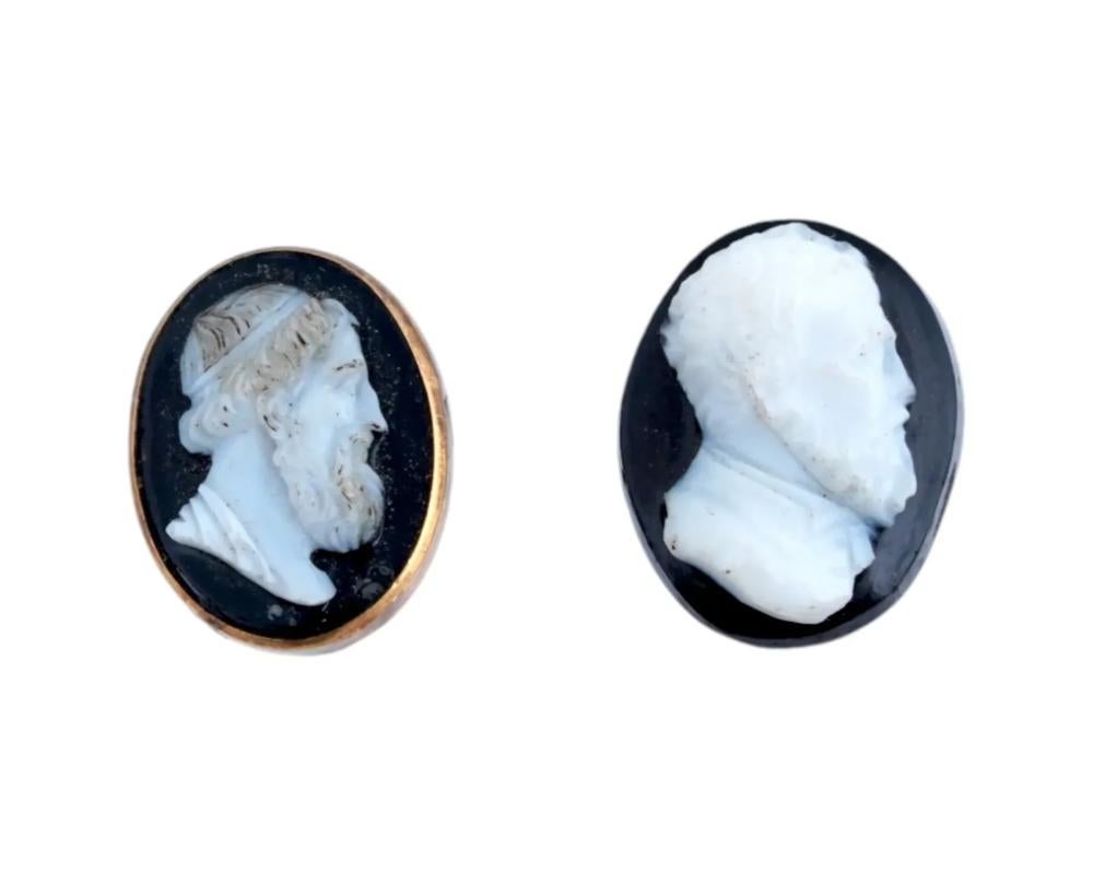 A pair of antique Roman oval carved Sardonyx stone cameos in two layers. The cameos are carved in raised relief, depicting male portraits in profile facing right. One is adorned with a gold tone frame. Ancient and Antique Roman Jewelry Wares and