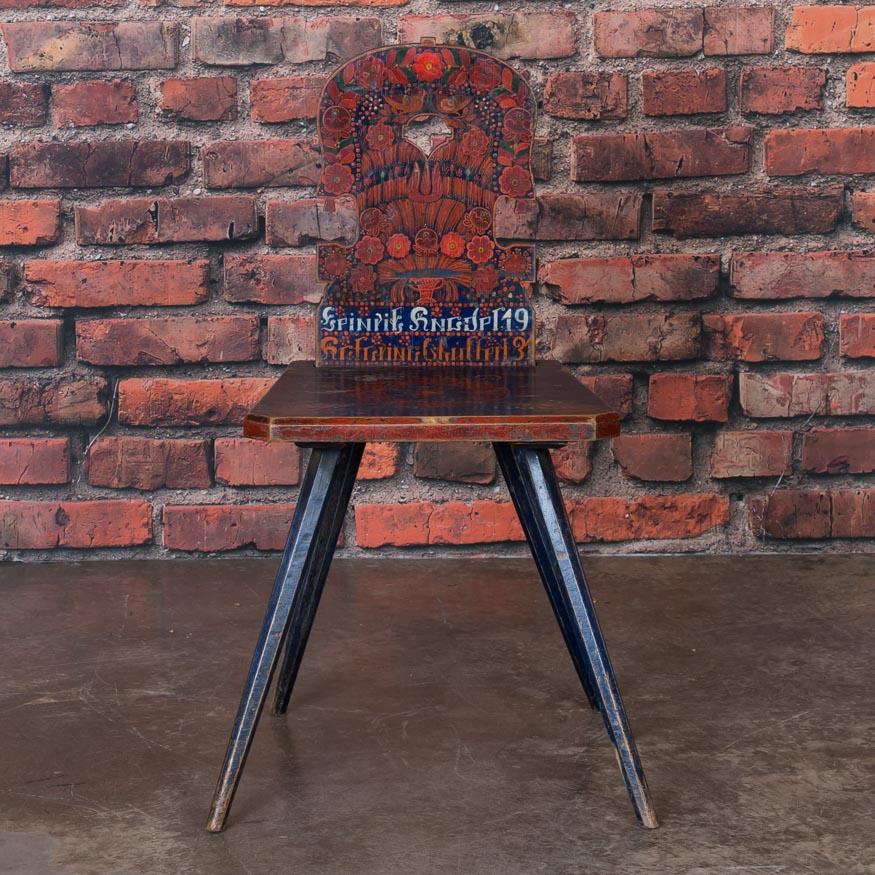 This highly painted, whimsical chair still maintains the original red and blue Folk Art paint of Romania. Birds, flowers, and even the date of 1913 embellish this delightful side chair with slanted peg legs. It is a wonderful example of traditional