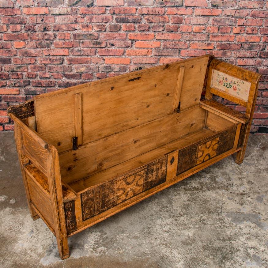 The quality and craftsmanship of this pine bench are exceptional with its traditional Eastern European Folk Art painted motifs. The deep, warm patina of the painted bench is enhanced by a wax finish that highlights the painted details. The seat is