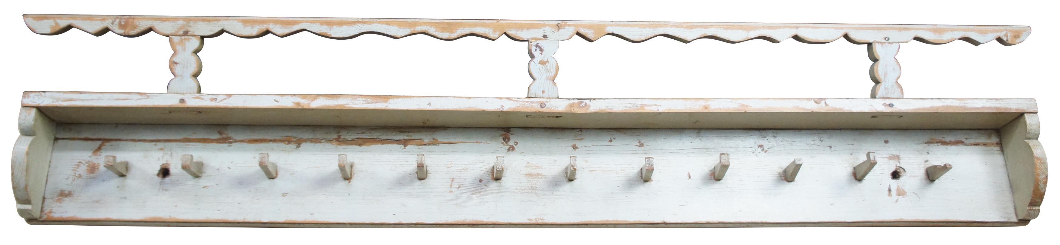 Late 19th century Romanian wall shelf. Often used in European country homes to display plates, cups or kitchen ware. Features three grooves along the top and twelve pegs. This would make a wonderful hanging rack in any mudroom, bathroom, hallway,