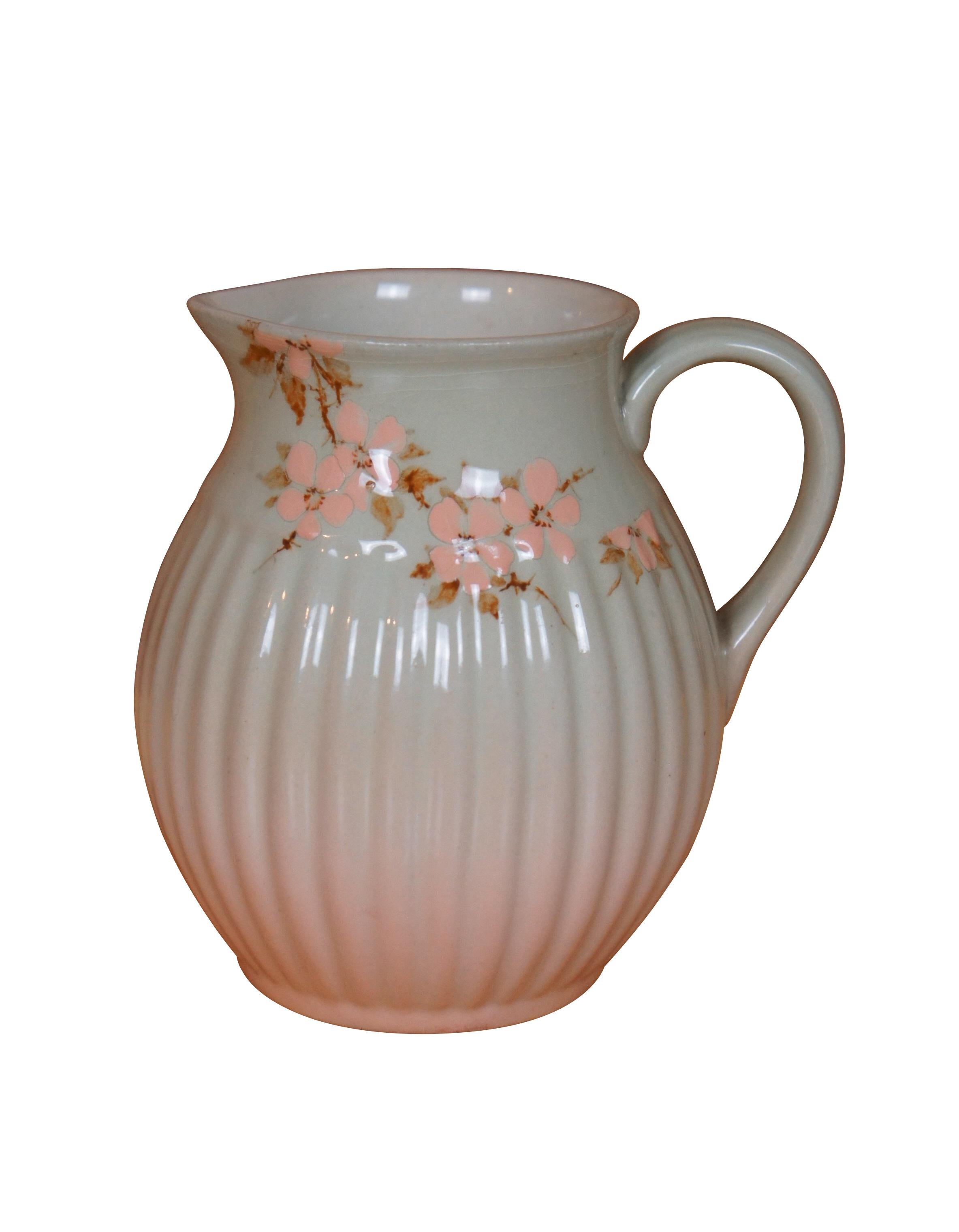 Antike Rookwood Creme Krug und Unterteller Schüssel / Untertasse von Sallie Toohey.  Sie ist mit einer floralen Iris-Glasur mit rosa und weißen Blüten sowie gerippten und geschwungenen Akzenten versehen.  CIRCA 1888 / 1889, Form 193 und 460. 

Sarah