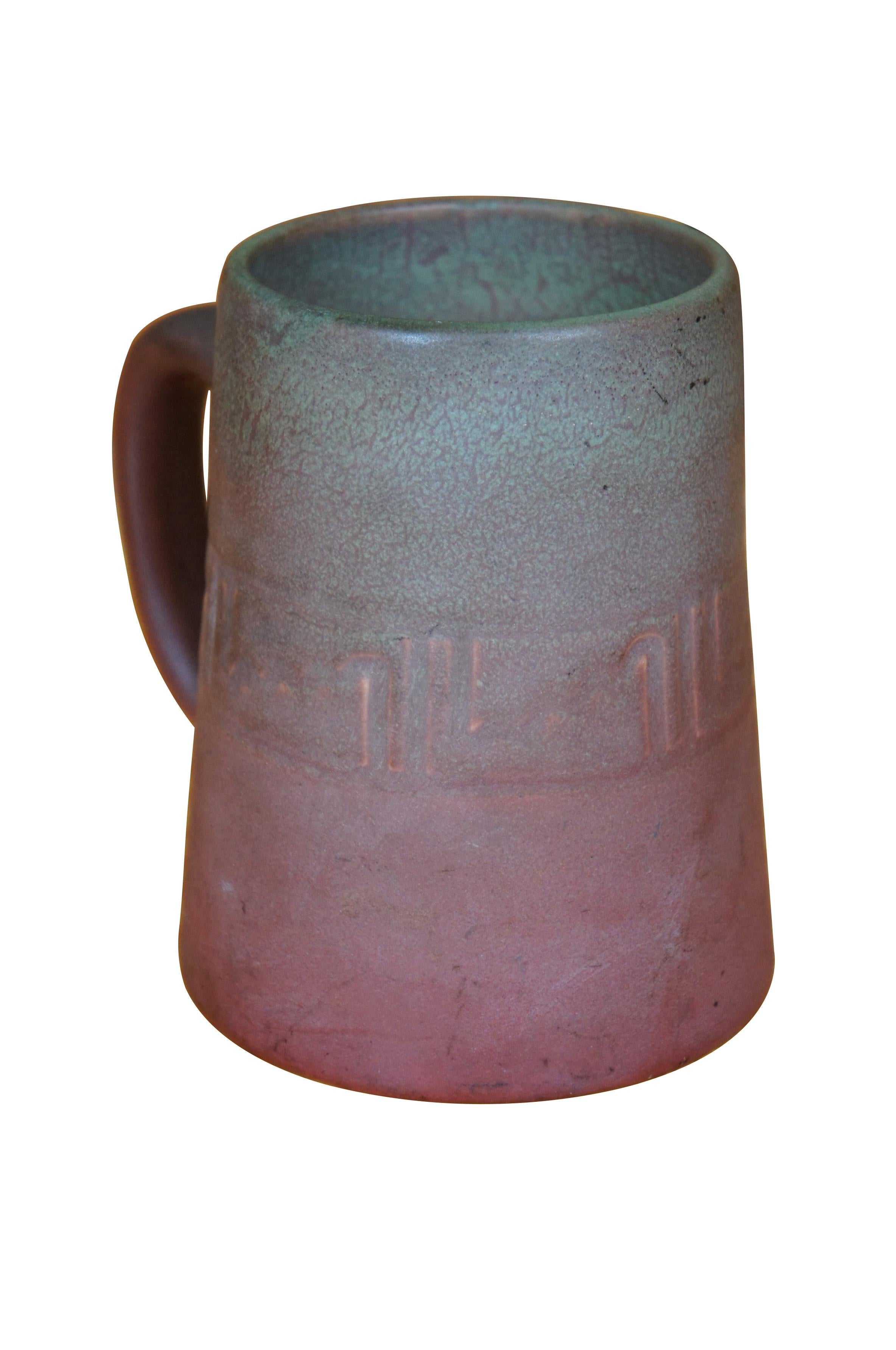 Ancienne tasse / stéine en glaçure vellum de Rookwood / art nouveau présentant une glaçure mate mouchetée de violet et de bleu avec une anse.  CIRCA 1905, forme 587, taille C.  

La lettre 