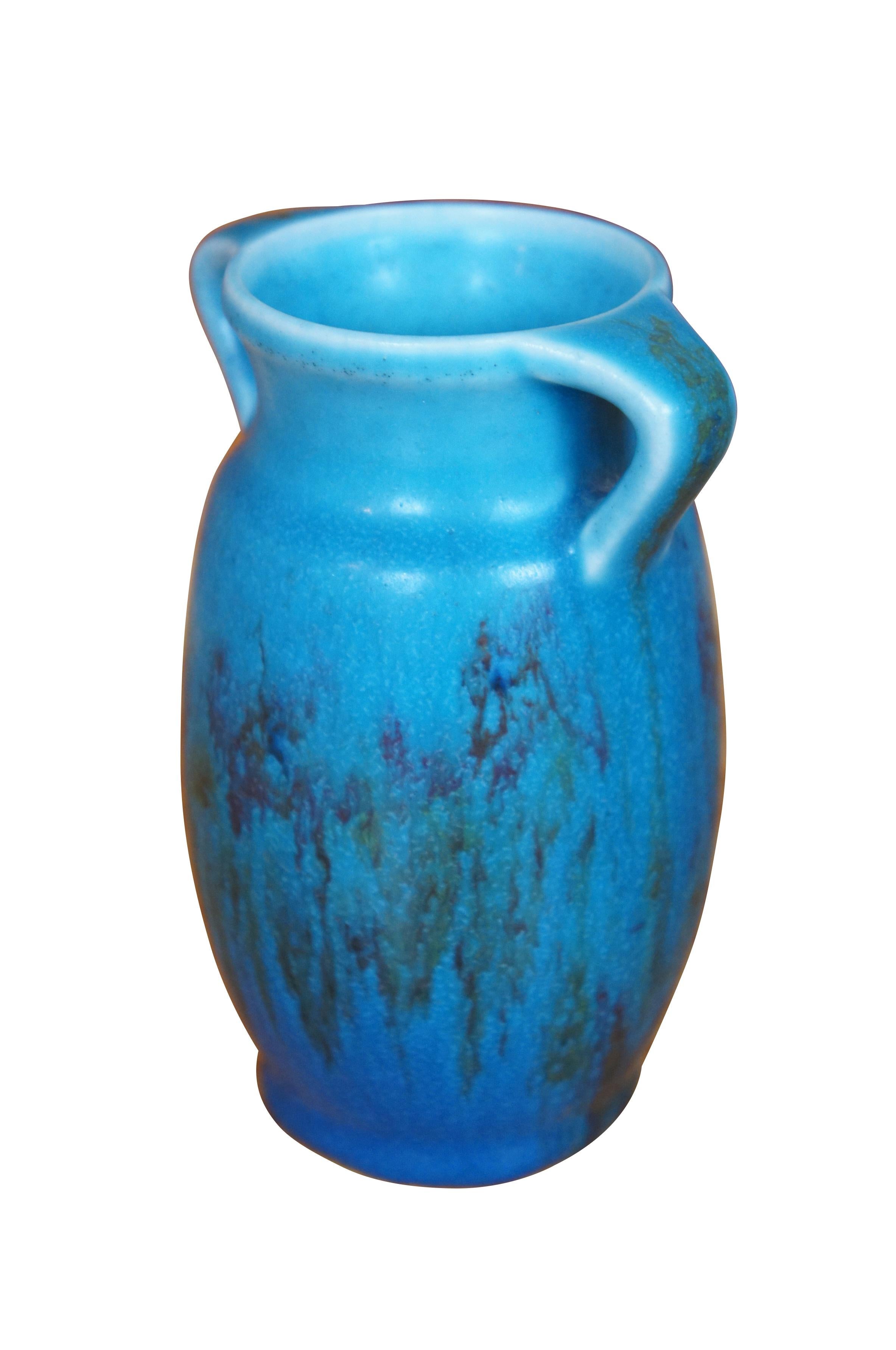 Antique Rookwood bud vase by Elizabeth Barrett.  It features Art Deco styling with wide opening, high handles and blue glaze.  Circa 1924 XXIV.  Shape 2557.  Marked with Elizabeth Barrett's mark of a cross in an oblong rectangle.

Elizabeth Barrett