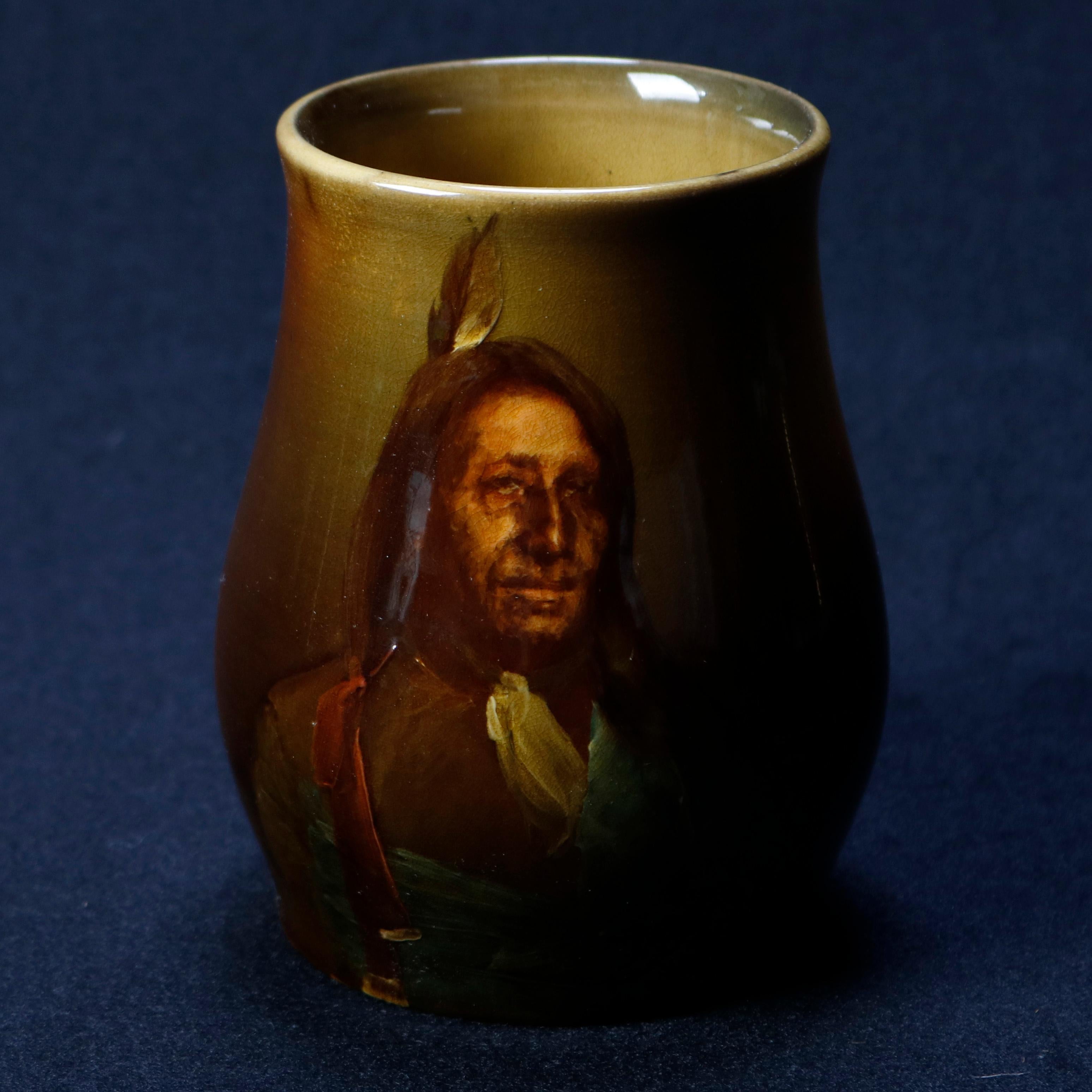 An antique art pottery portrait mug by Albert Valentien for Rookwood offers finely hand painted portrait of American Indian with headdress, maker mark and initialed on base as photographed, circa 1890

Measures: 5.25