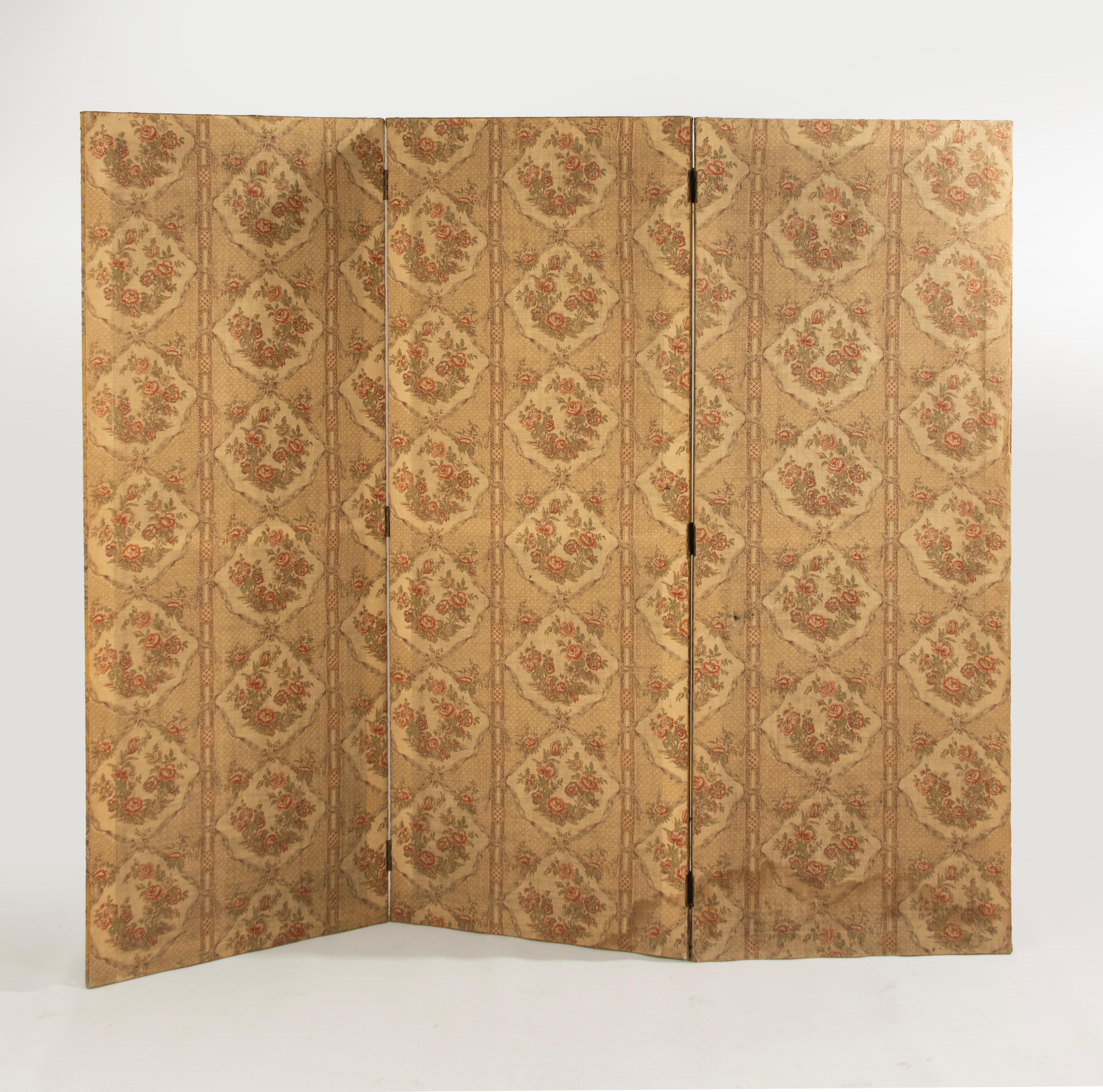 A  beautiful folding screen / room divider with three panels. The base is made of pine, upholstered with a seamless pattern fabric depicting a Chinese scene with mother and child. The backside is upholstered as well. One small damage at the fabric