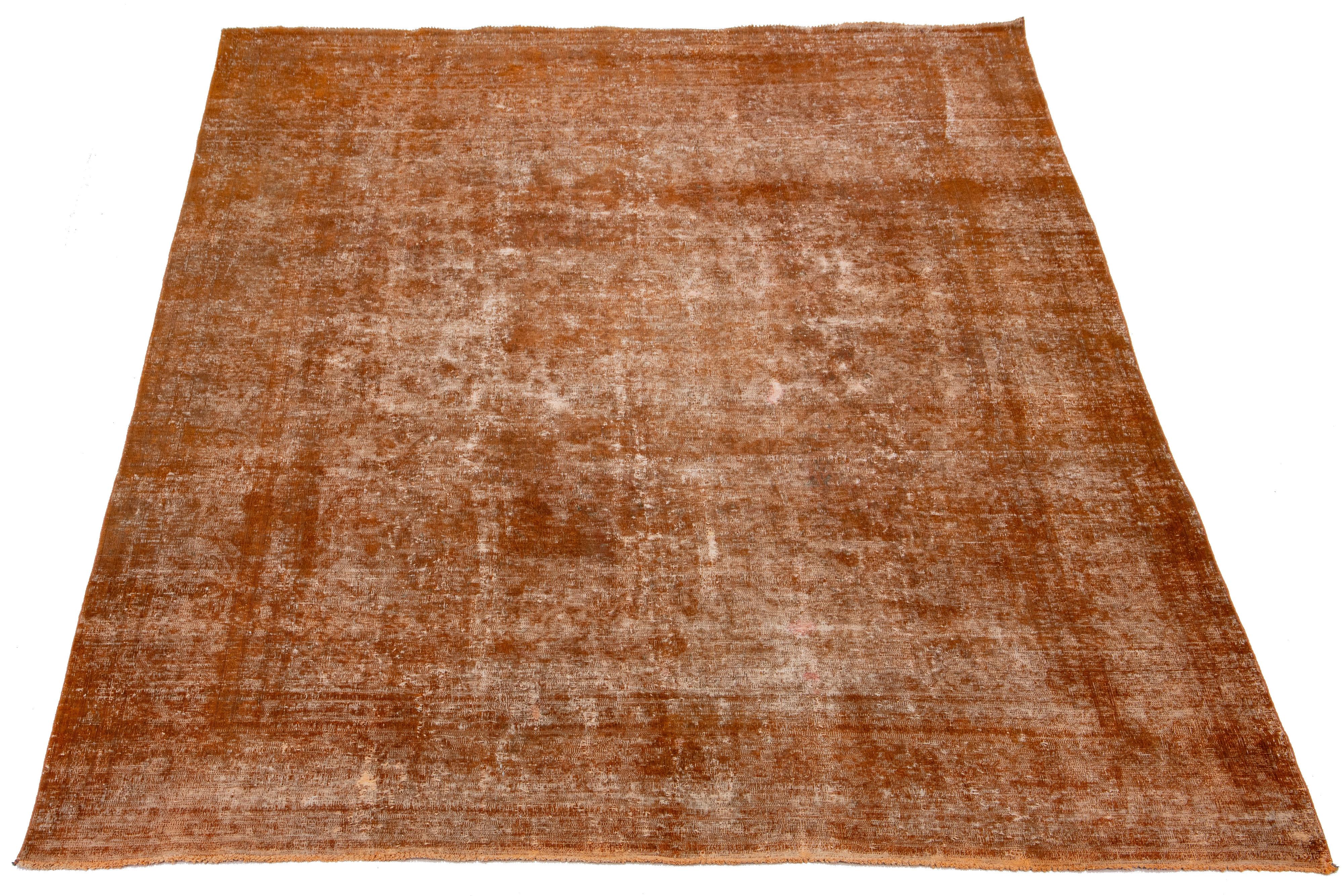 This antique orange Persian wool rug showcases an allover design with gray and brown accents.

This rug measures 9'5'' x 12'4