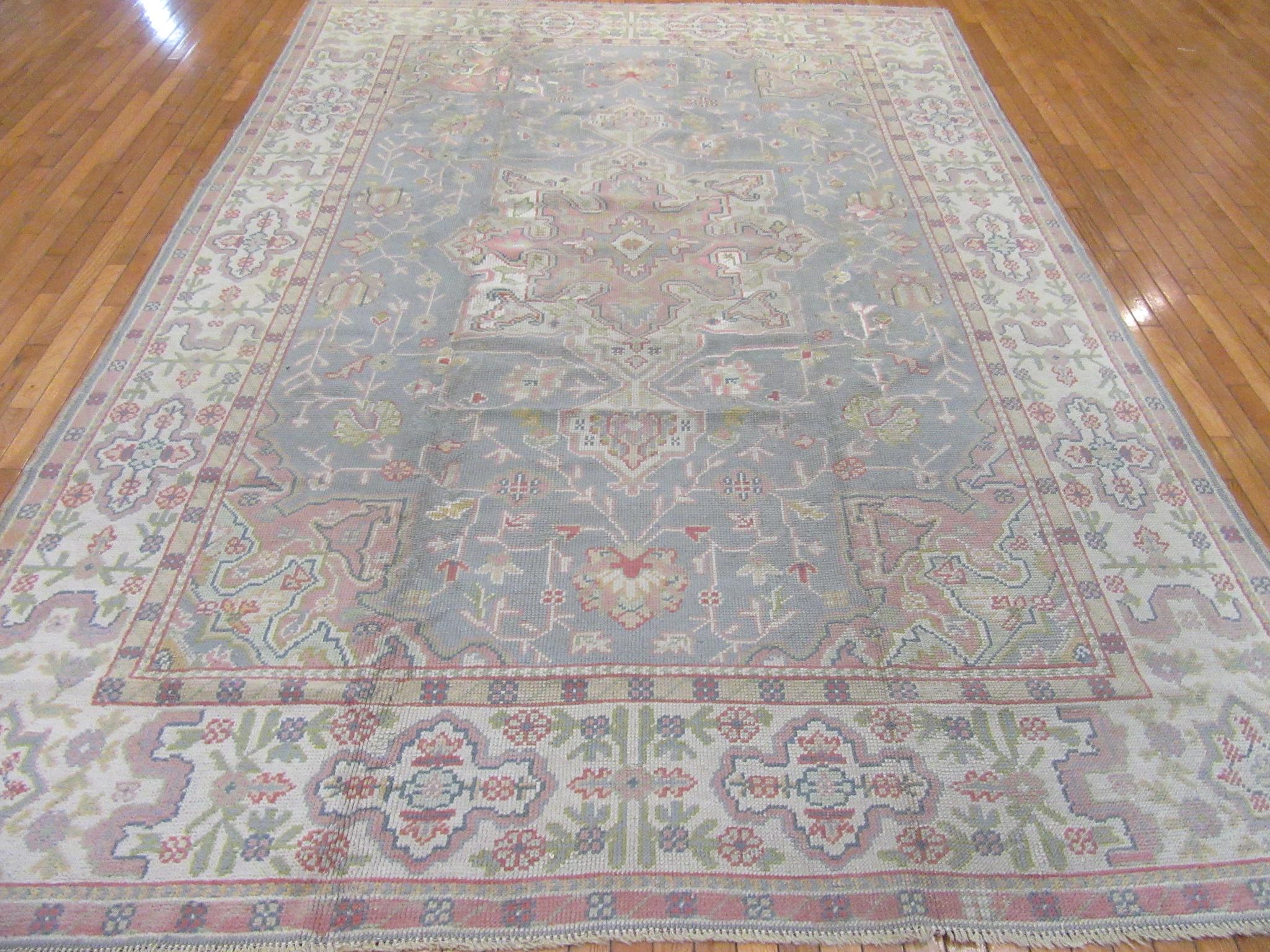 This is a hand-knotted room size 8' 1'' x 11' 8'' antique Turkish Oushak rug with a unique color combination. This beautiful rug is in very good condition made with wool.