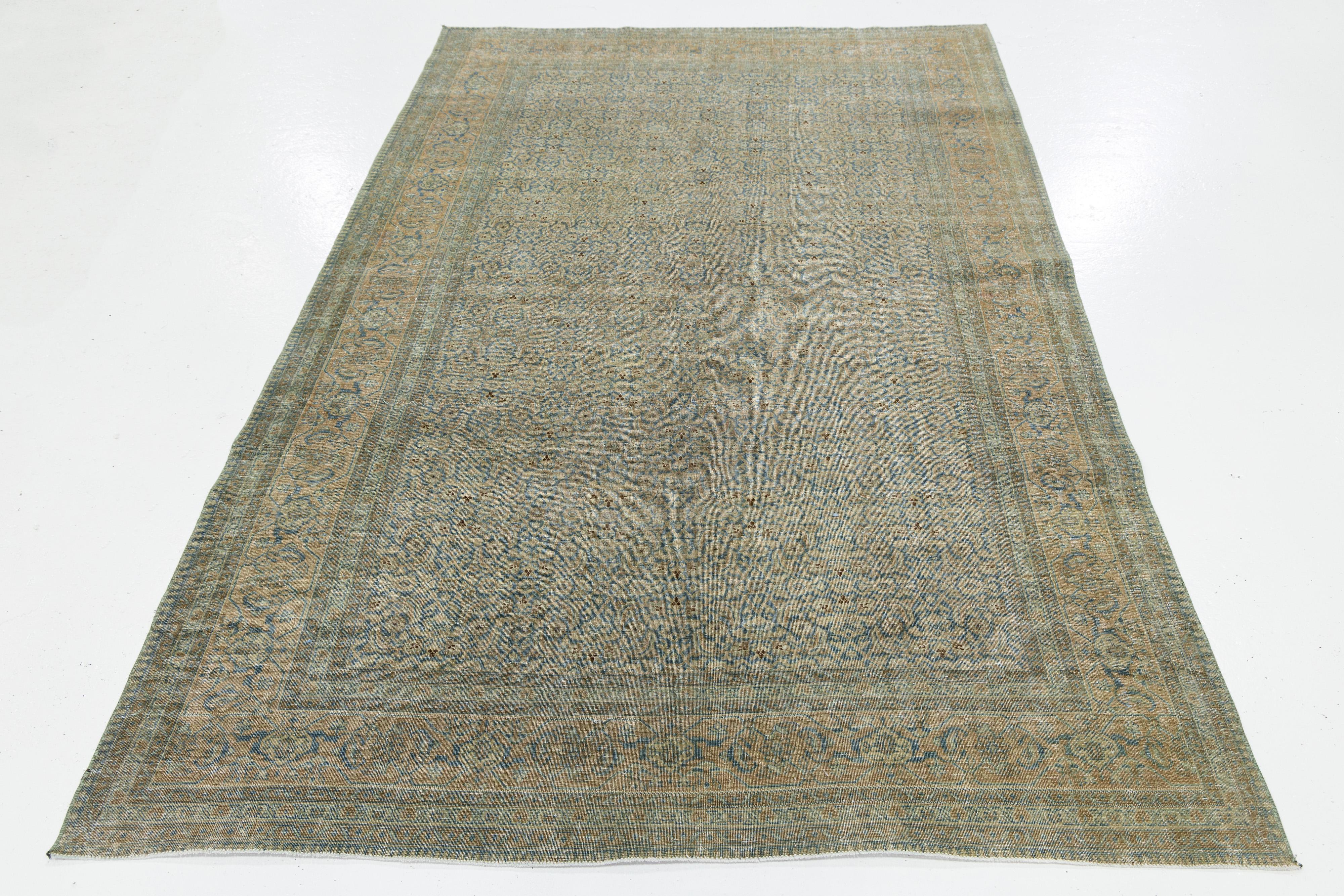 Dieser antike persische Täbriz-Teppich zeigt ein lebhaftes blaues Feld, das mit einem bezaubernden floralen Allover-Muster verziert ist. Ergänzt wird das Design durch zarte hellbraune Akzente, die eine harmonische Ästhetik schaffen.

Dieser Teppich