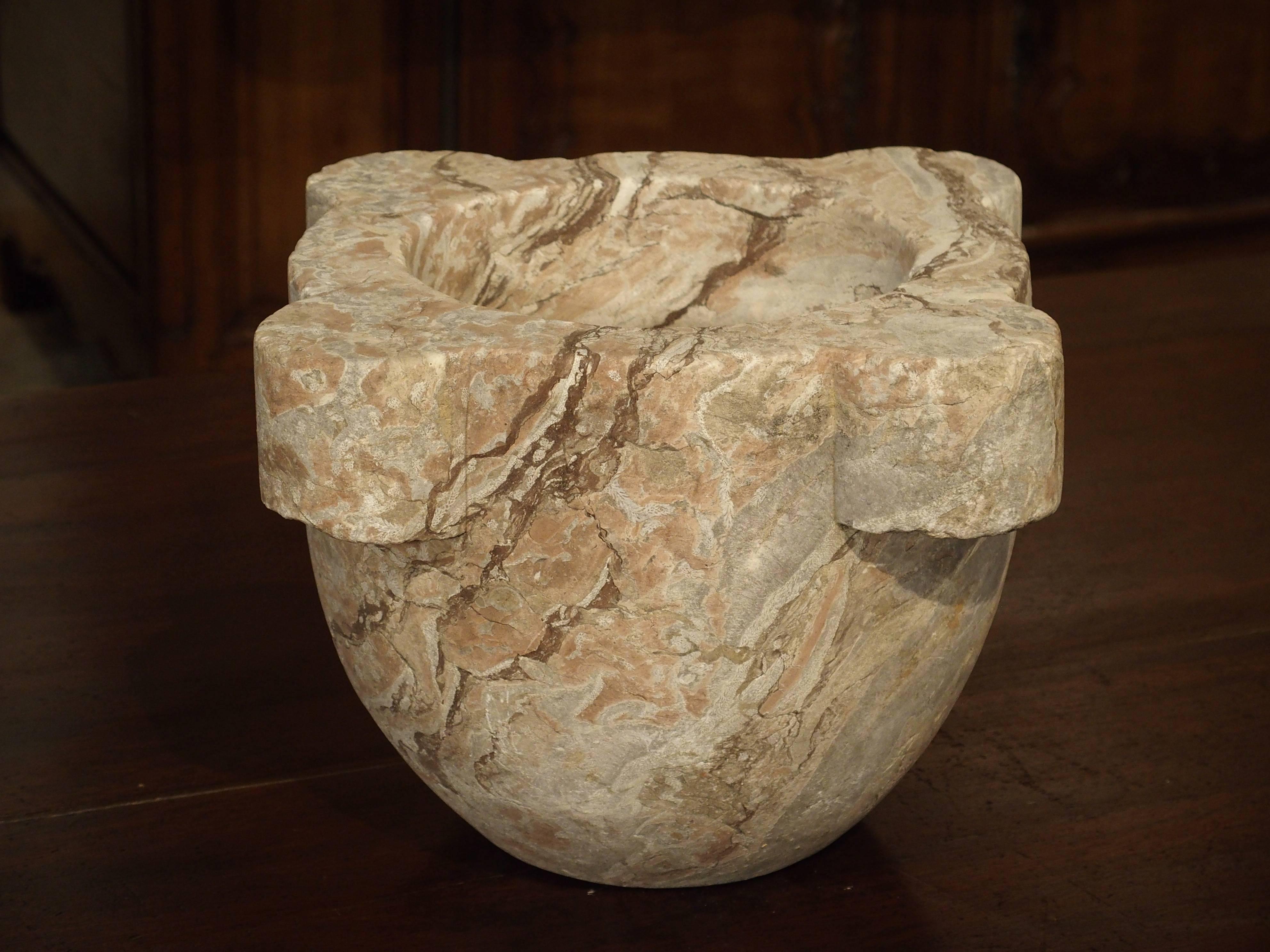 This large and beautiful marble mortar is from France and dates to the 19th century. It is made from an antique rose, cream, and gray colored marble and has four out turned motifs. In France, these were used in the kitchens of grand chateaux. They