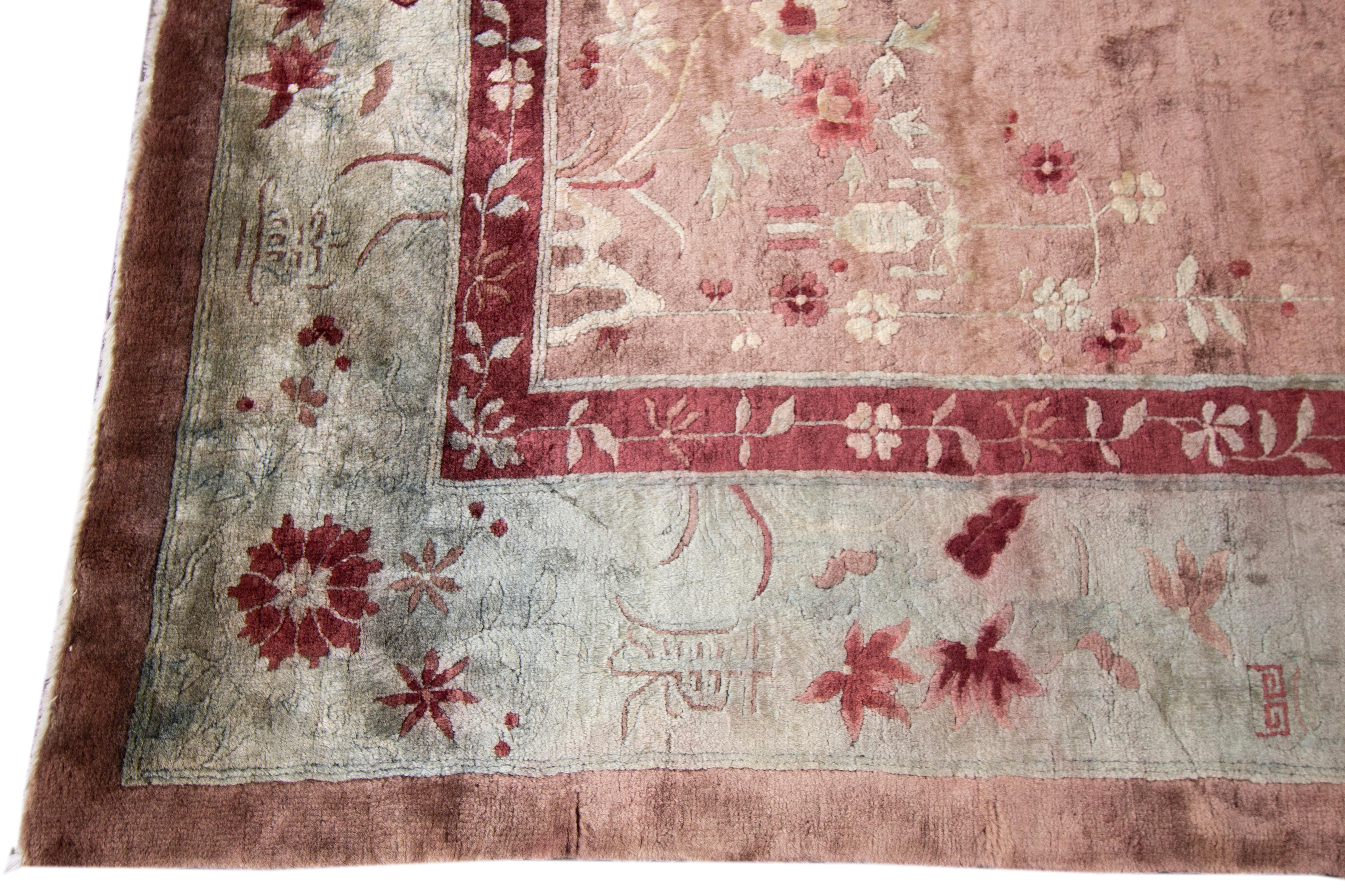 A beautiful Chinese Art Deco hand knotted wool rug with a rose field blue frame and multi-color accents in all-over Chinese floral design.

This rug measures 9'9