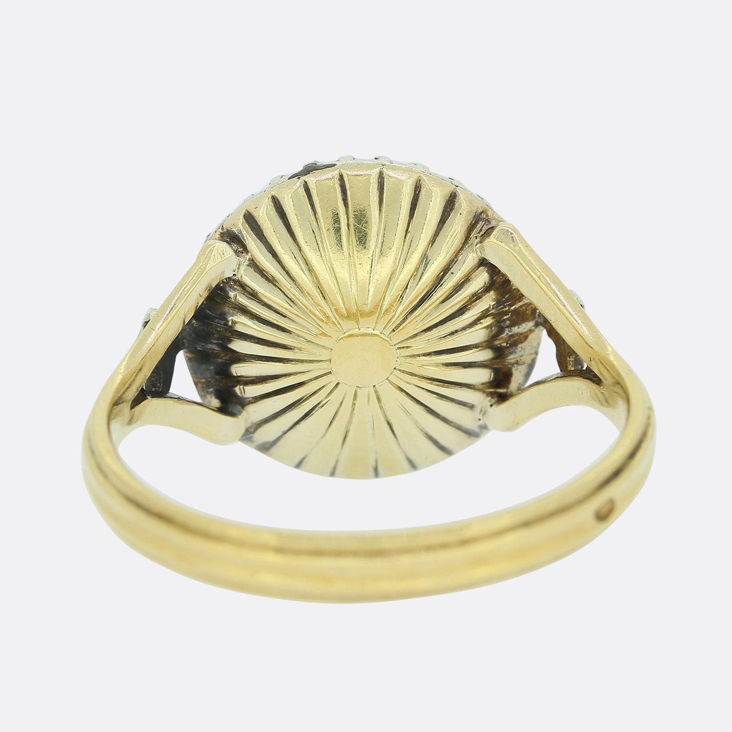 Si tratta di un raro anello con diamante antico di epoca georgiana. Il diamante centrale a taglio rosa alto e grosso è circondato da una serie di diamanti a taglio rosa a cupola incastonati in argento, il cui supporto smerigliato ha perso