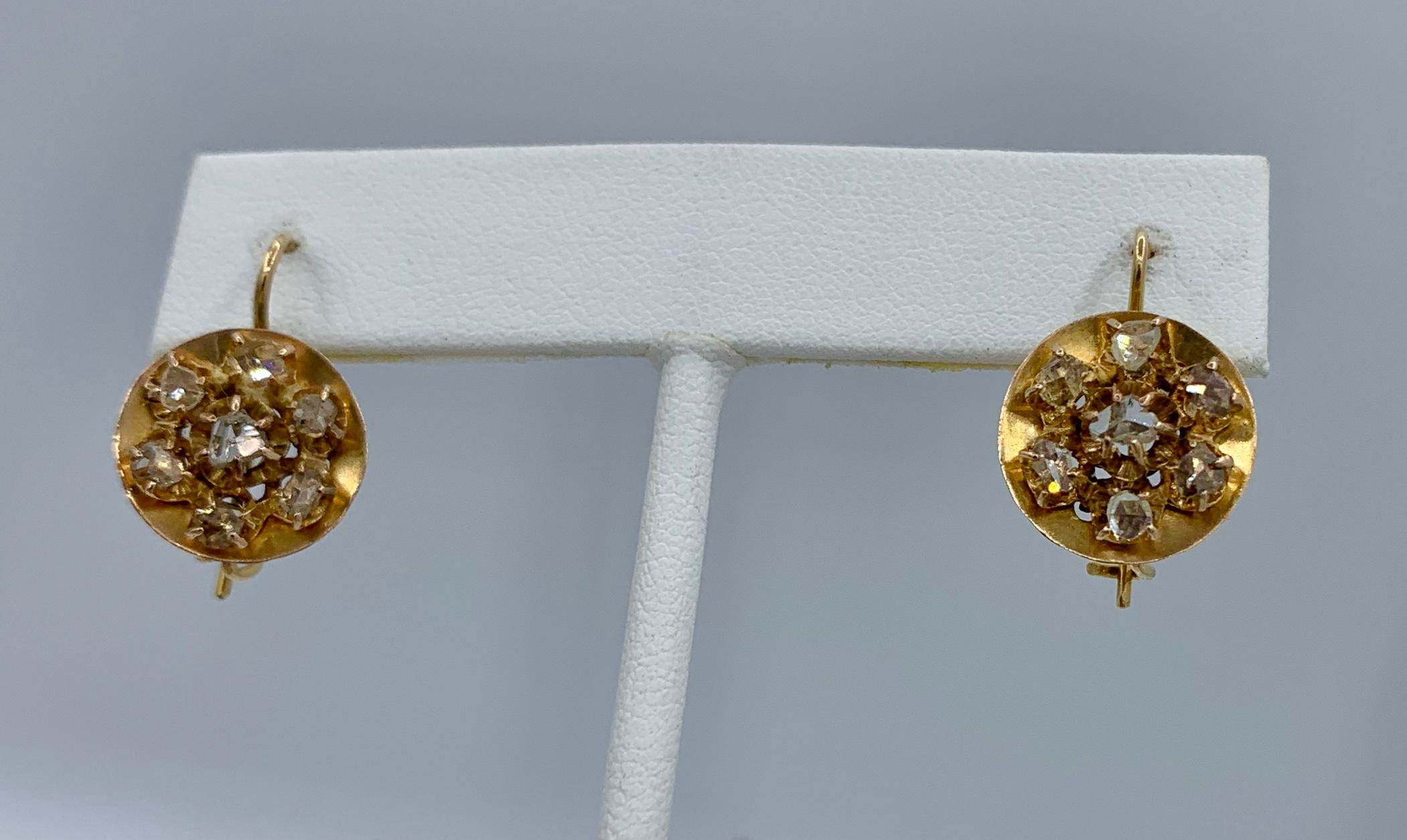 This is rare pair of antique Rose Cut Diamond Dangle Drop Diamond Cluster Earrings in 14 Karat Gold.  They have extraordinary design with a central diamond surrounded by six additional Rose Cut Diamonds all individually prong set. 
The earrings have