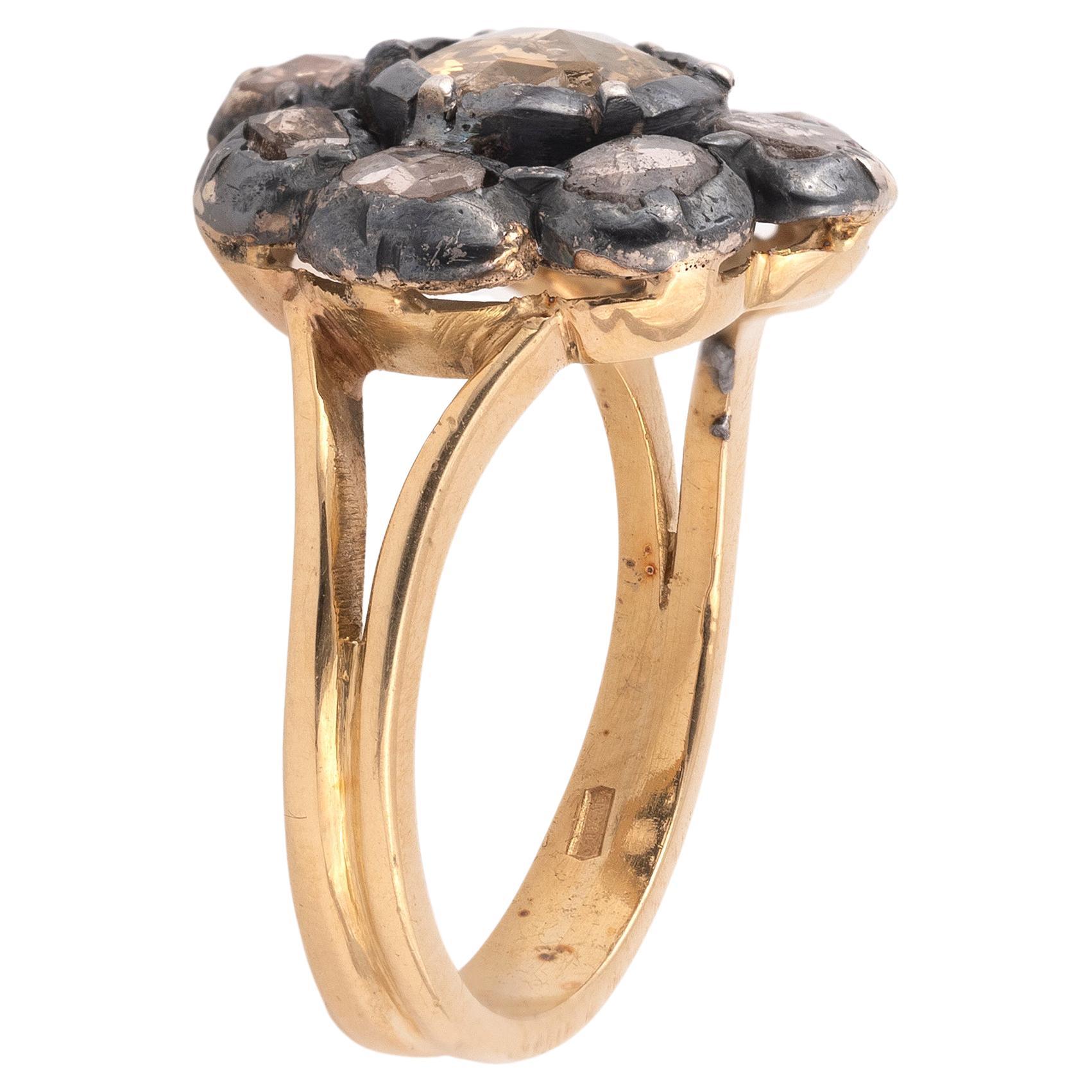Of round outline, the central stone weighing approximately 1cts, it is bordered by nine smaller stones weighing approximately 0,90cts, claw set in silver and gold.
Weight: 6.4gr.
Size 7 1/4