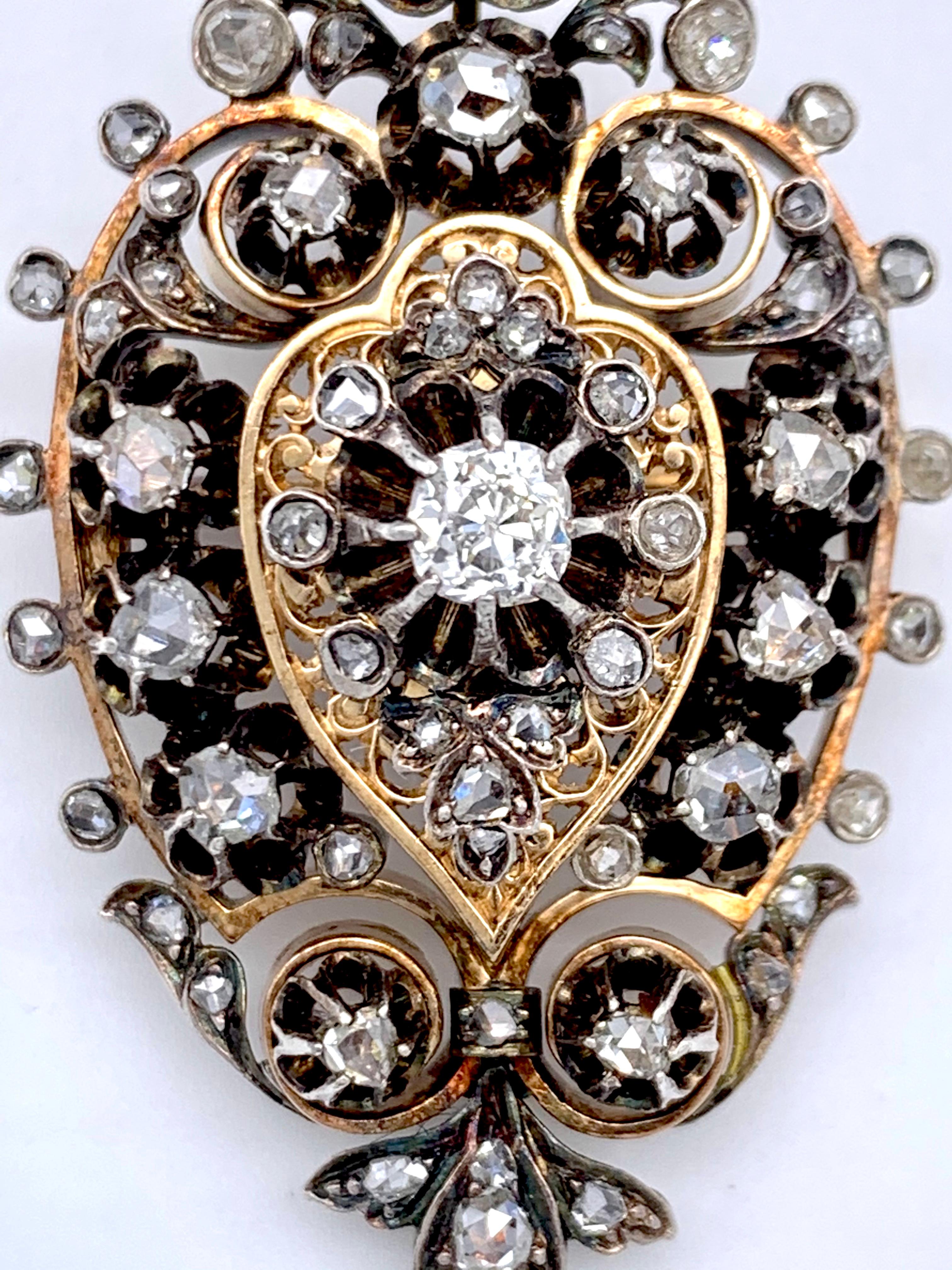 This versatile piece of jewellery can be worn as a pendant or brooch. The pendant loop is on a hinge that can be folded in and out. The rose diamonds are set in silver and backed onto a gold mount. The centre section is designed in the shape of a