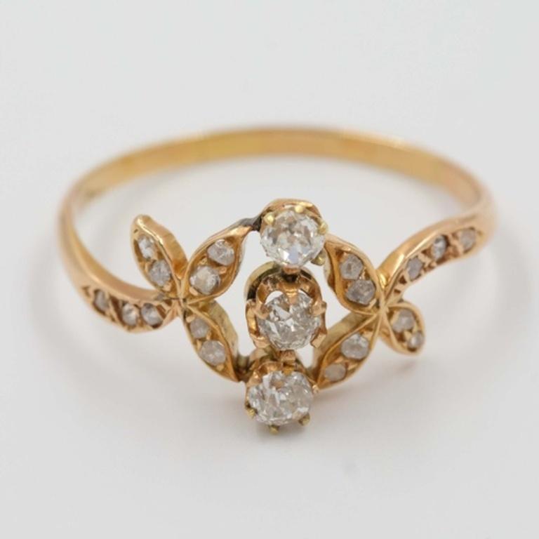 Beautiful antique rose cut diamond ring with three big rose cut diamonds and by many little ones around them. The diamonds are set in gold-toned metal. 