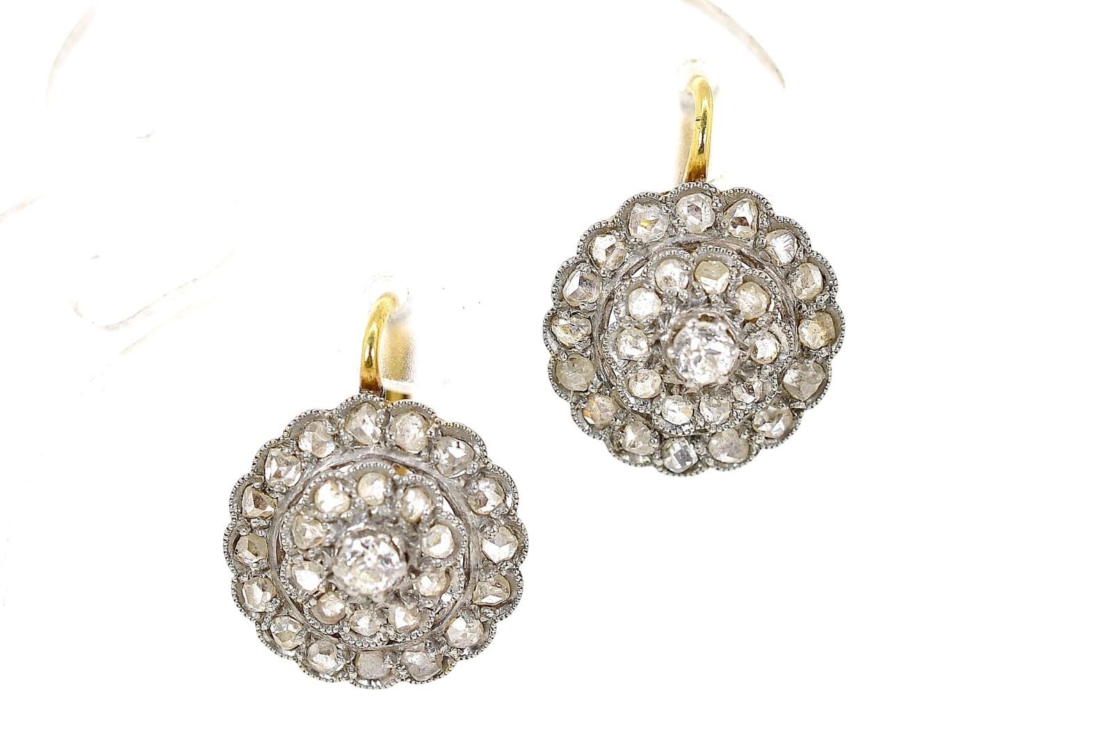 These quintessential 1920s cluster earrings are created in platinum topped 18KT yellow gold.  They are a prime example of simple yet sophisticated everyday earrings.  Each center is set with one Old European Cut Diamond surrounded by Rose cut