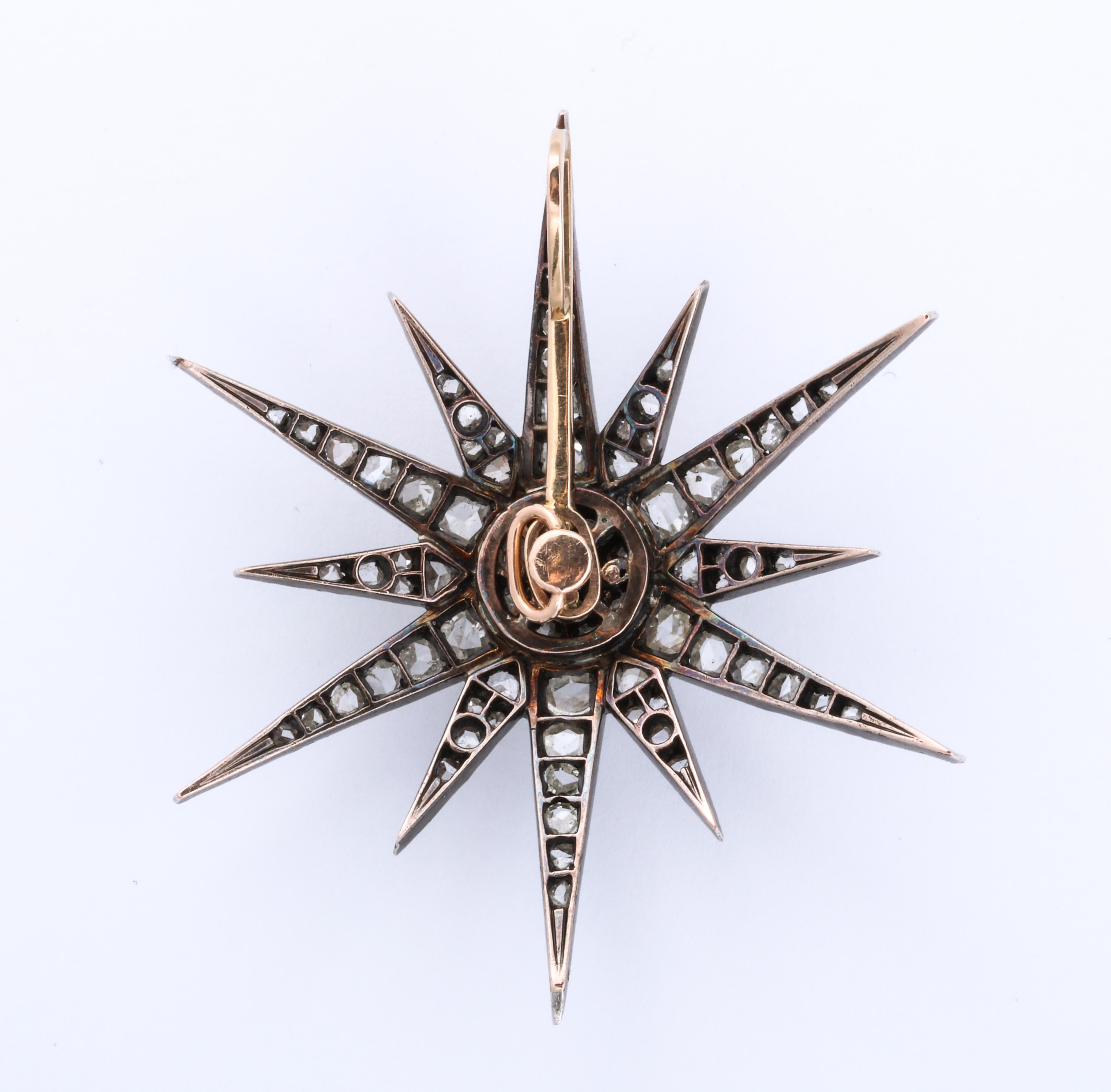 Impresionante y coleccionable estrella antigua con diamantes talla mina engastados en oro que puede llevarse como colgante o broche. Tiene su fijación temblorosa original. También se muestra con una cadena de platino y diamantes que se vende por