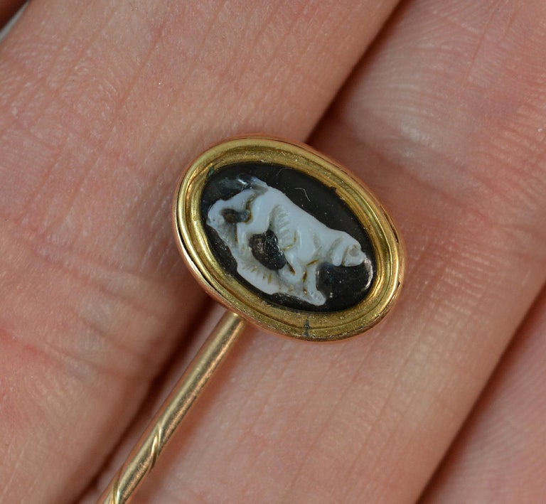 A rare Georgian period stick tie pin.

Modelled in solid rose gold with twist stem to pin and closed back setting.

Designed with an oval shaped agate panel to top. Carving depicts a hound ? dog in white with black background.


CONDITION ; Good for