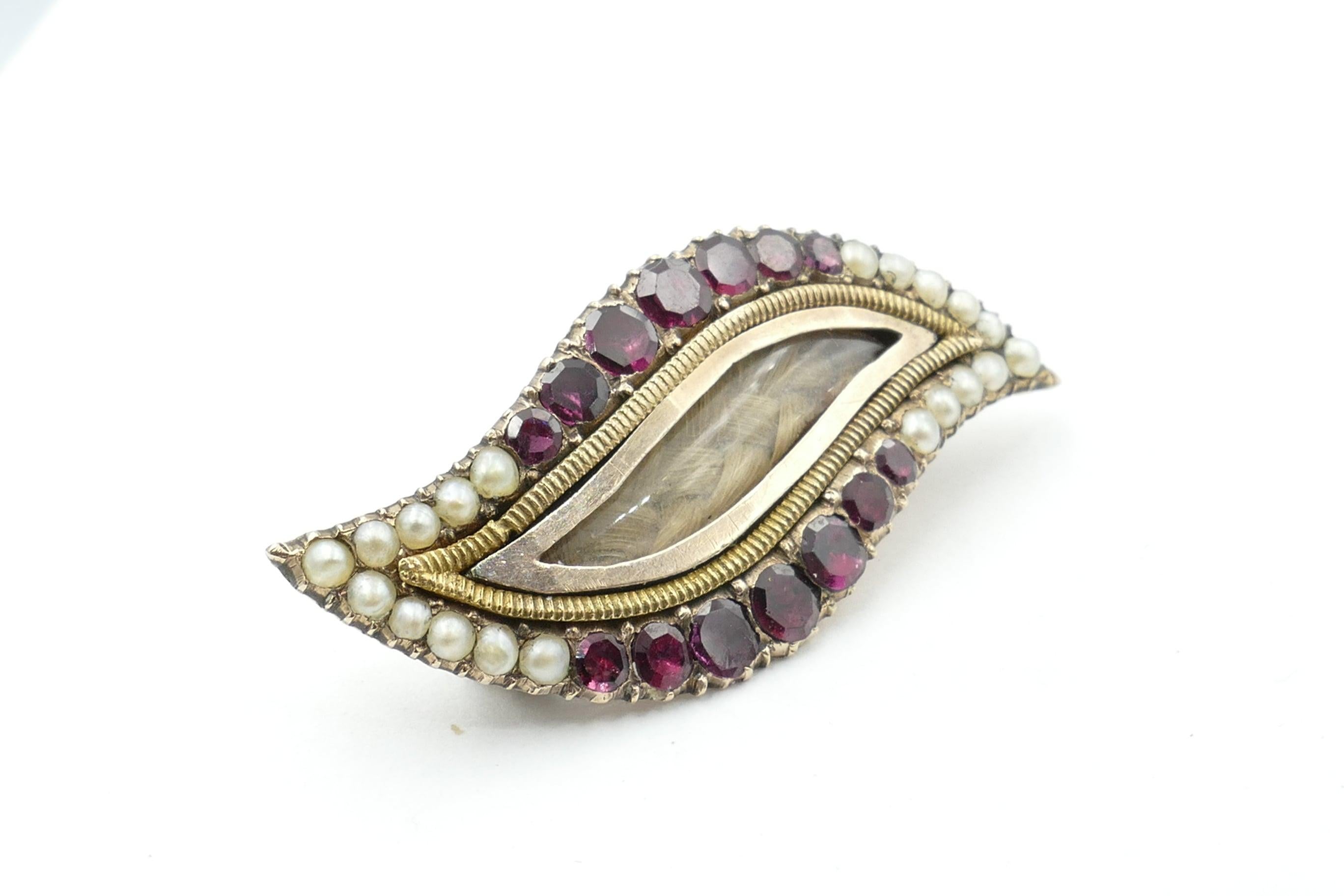 This lovely Antique Mourning Brooch/Pendant features 14 Garnets, graduated from 2.06mm - 3.08mm Diameter range, of a strong Purplish/red Colour, Tone medium-dark, Clarity eye-clean, Round cut, Micro-claw set.
As well there are 20 old Seed Pearls,