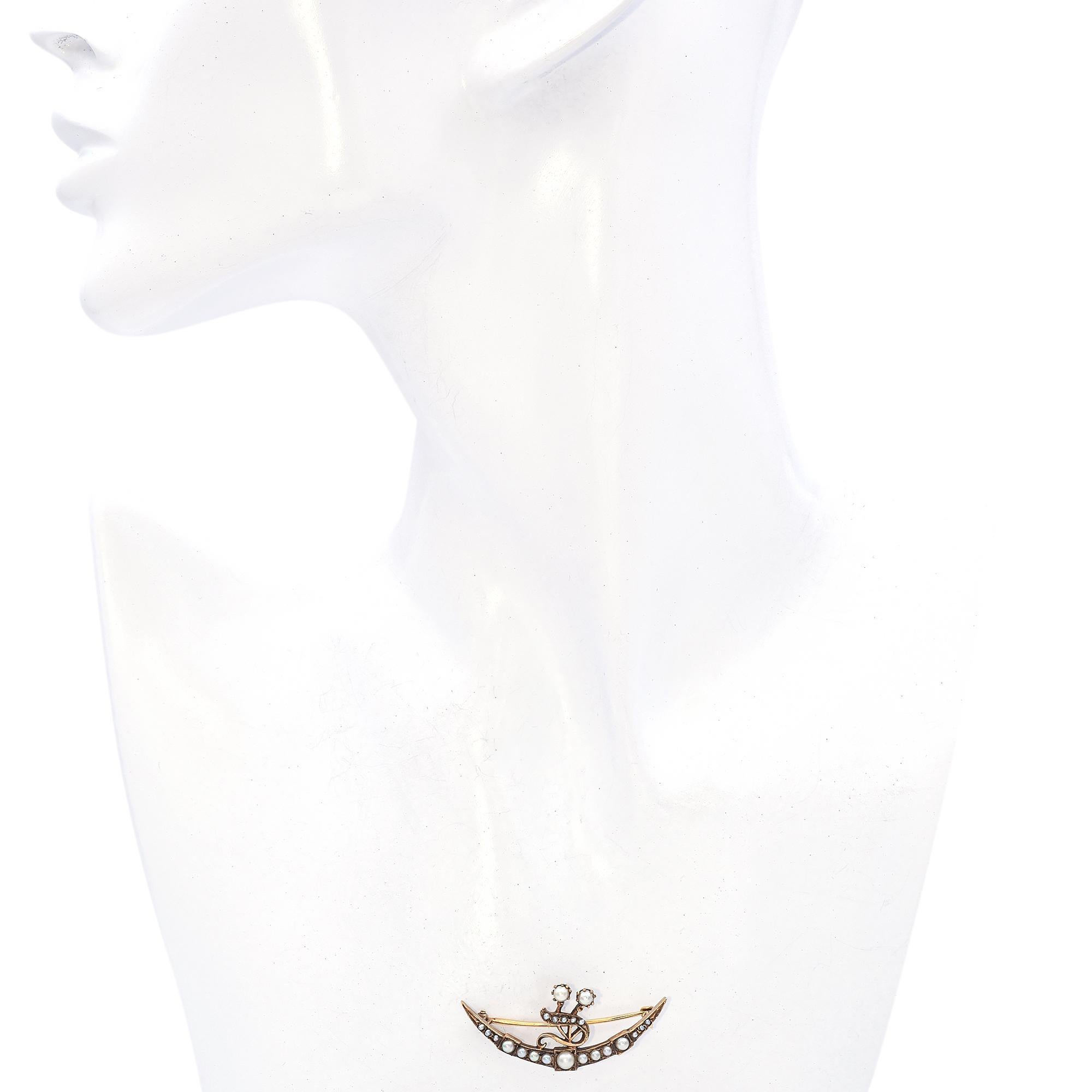 This Art Nouveau gold brooch design features a crescent shape embellished with a series of pearls, culminating in a central floral motif. The pearls are set in a delicate arrangement, enhancing the brooch's elegant curvature.

Weight: 4.1
