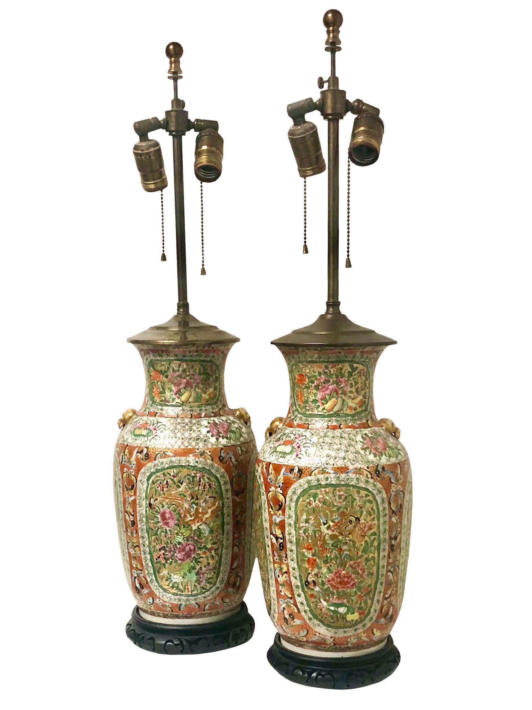 A pair of 19th century rose medallion vases both are in excellent condition probably converted into lamps in the 1950s. They are very unusual butterflies and birds and flowers and It has the little foo dogs on each side of the vases. They are in