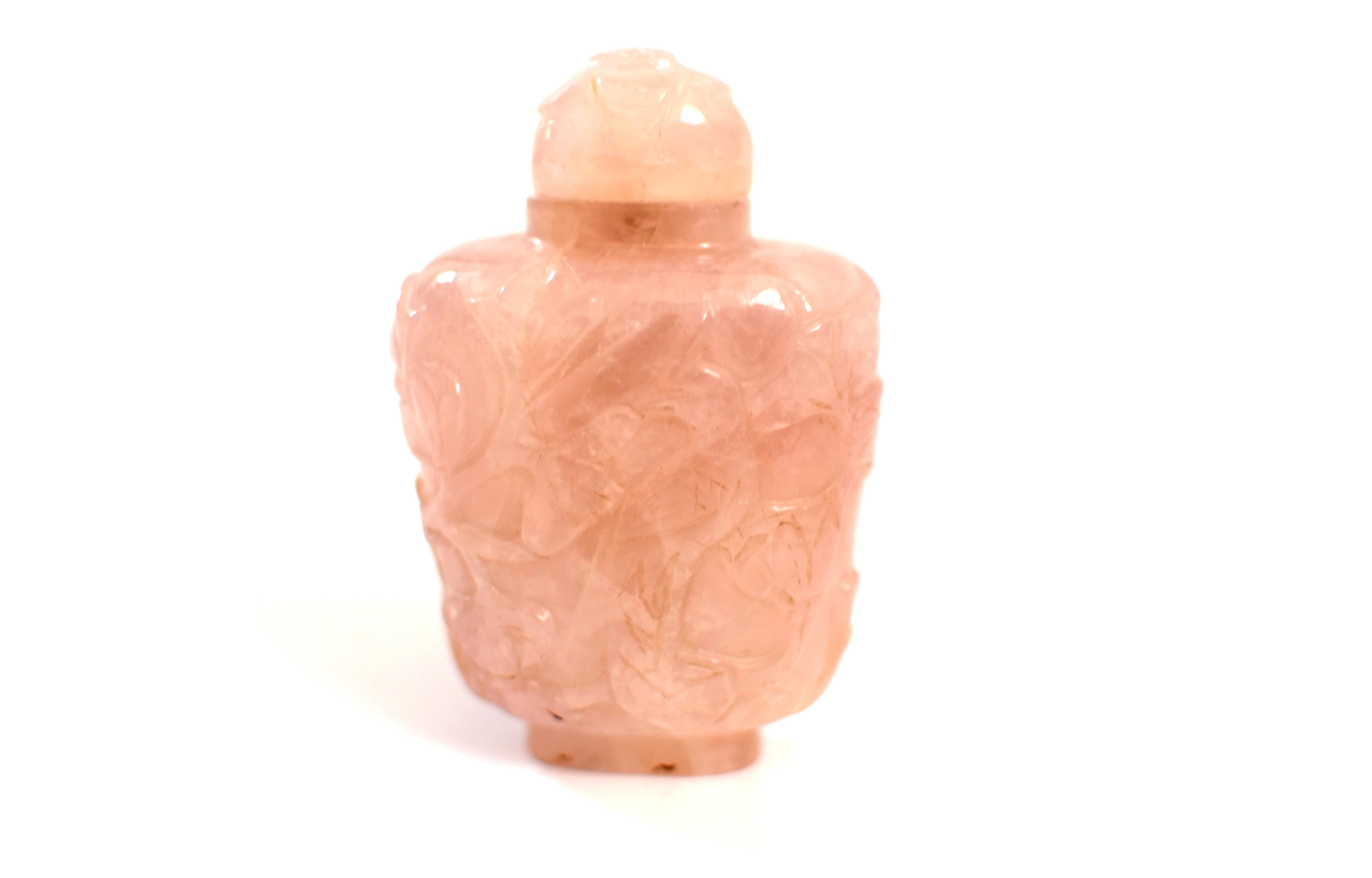 A beautiful 19th century natural rose quartz Chinese snuff bottle. Carved on one side a regal phoenix standing upright in front of a tree of twirling branches and foliage which wraps around the bottle covering the other side. Top of the bottle