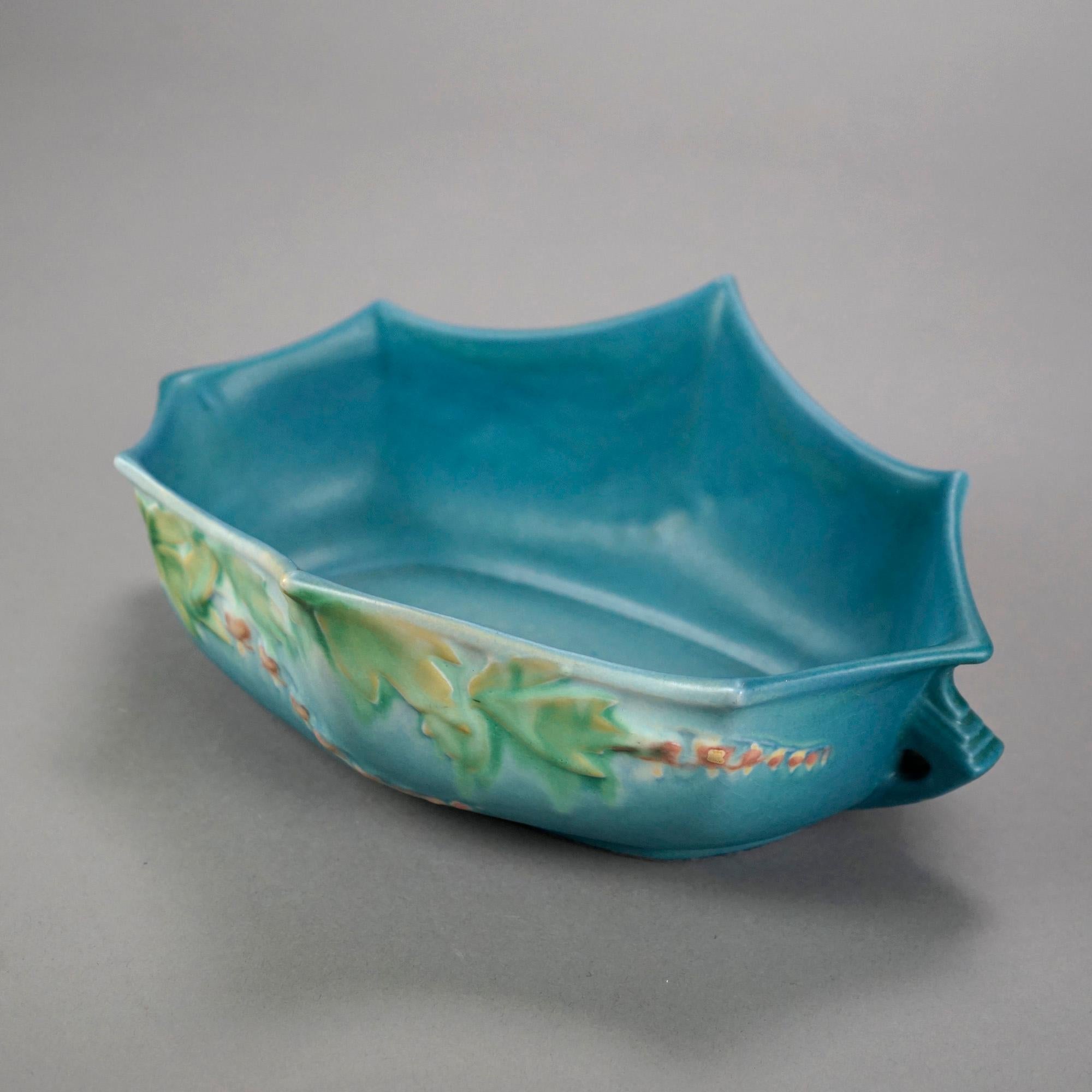 An antique console bowl by Roseville of the Bleeding Heart pattern in blue offers art pottery construction with scalloped rim and double handles, maker signed on base as photographed, 20th century.

Measures- 4.25''H x 11.75''W x 8.75''D.

Catalogue