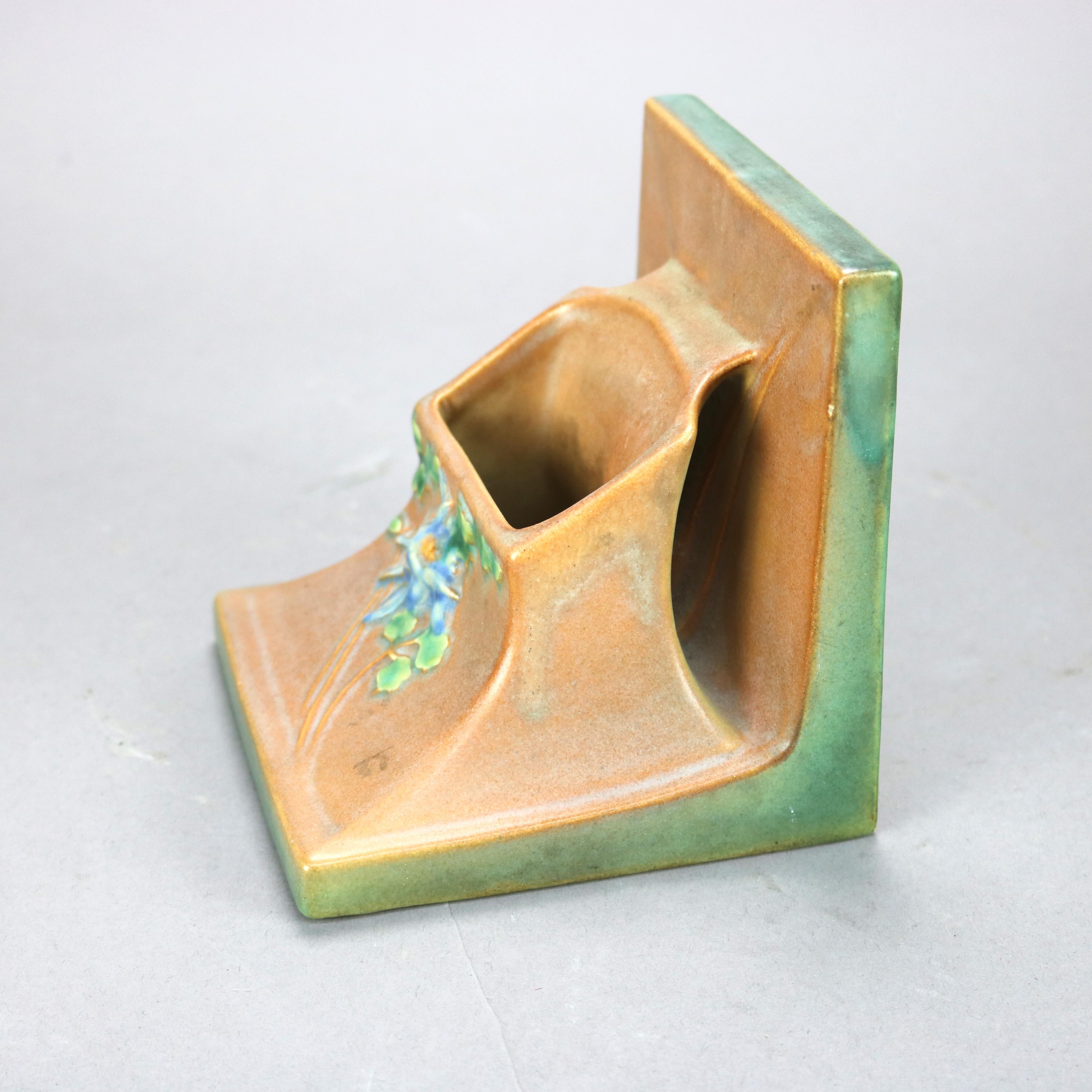 An antique vase by Roseville offers art pottery construction with bookend form having floral element in relief, base signed as photographed, c1930

Measures - 5.25'' H x 5.25'' W x 5.25'' D.

Catalogue Note: Ask about DISCOUNTED DELIVERY RATES