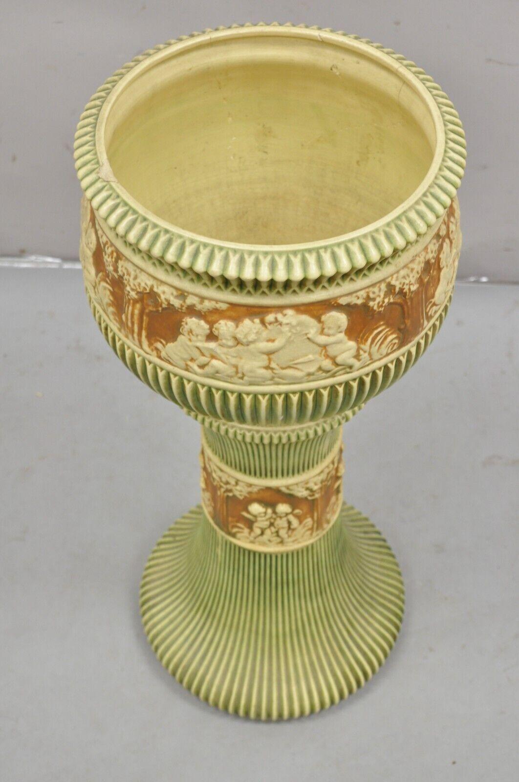 Antique Roseville Donatello Cherubs Art Pottery Jardiniere & Pedestal Flower Pot Set - 2 Pc Set. Circa Early 1900s. Dimensions : 29