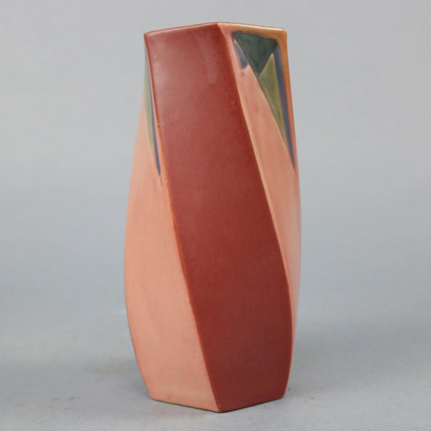 An Art Deco Roseville art pottery vase in the Futura pattern offers twisted and faceted form with contrasting geometric reserves, label segment on base as photographed, circa 1920.

Measures: 8.25