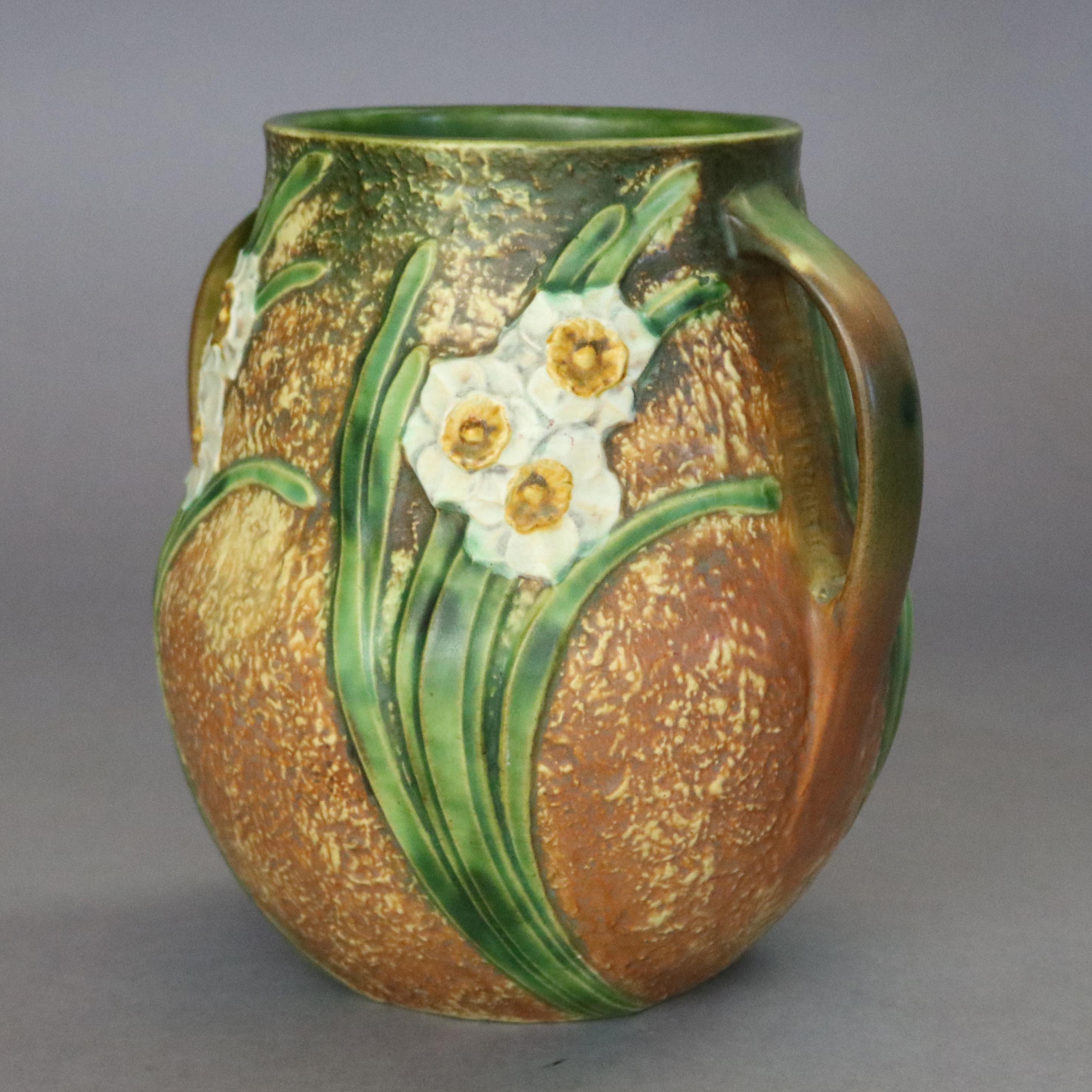 An antique art pottery vase by Roseville in Jonquil, pattern 530-10, offers double handled vase with textured finish having daffodil decoration, circa 1930

Measures: 10