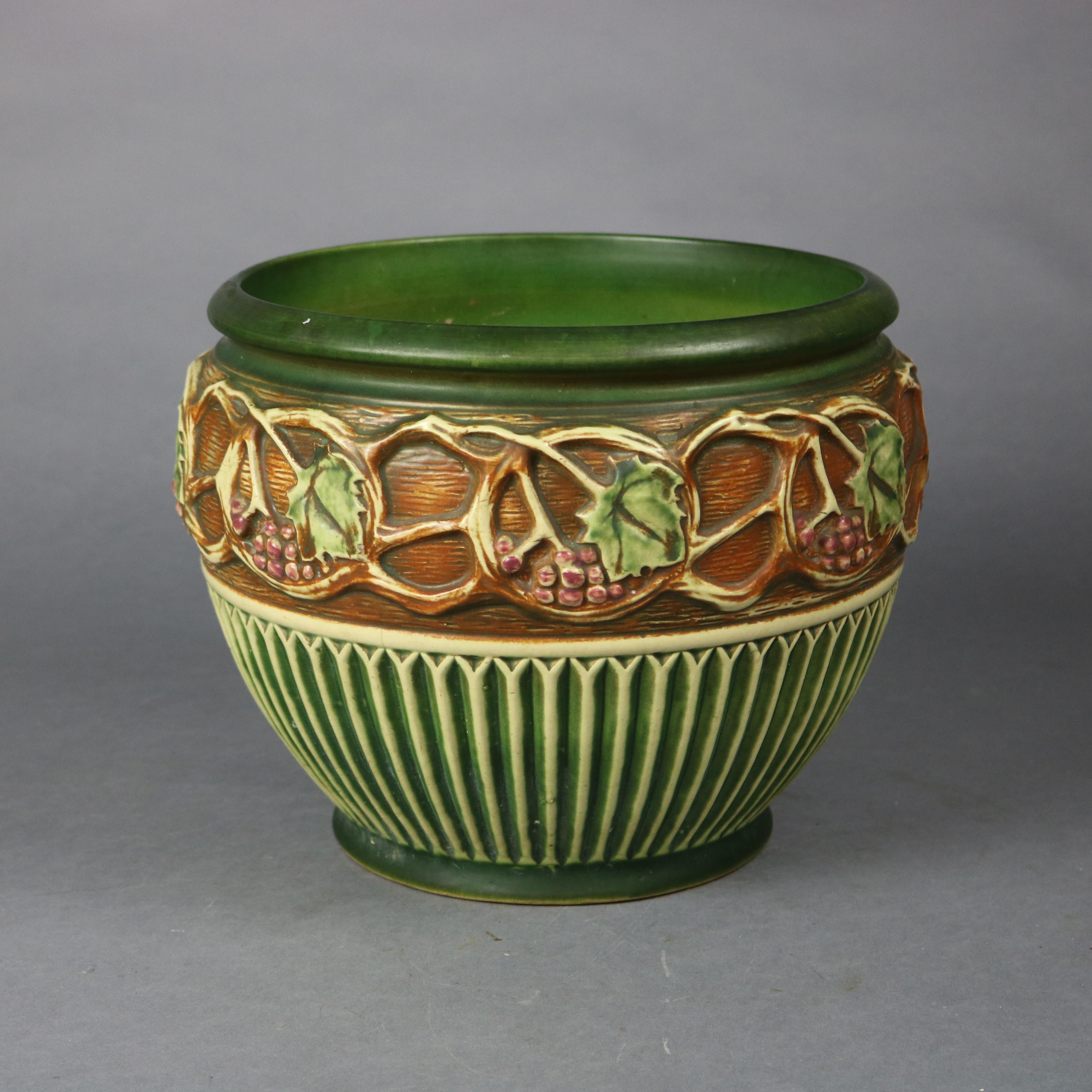 An antique jardiniere by Roseville offers art pottery construction in Normandy pattern with grape and leaf band, maker mark on base as photographed, c1930

Measures - 9.75'' height x 12'' diameter, 9''diam opening.