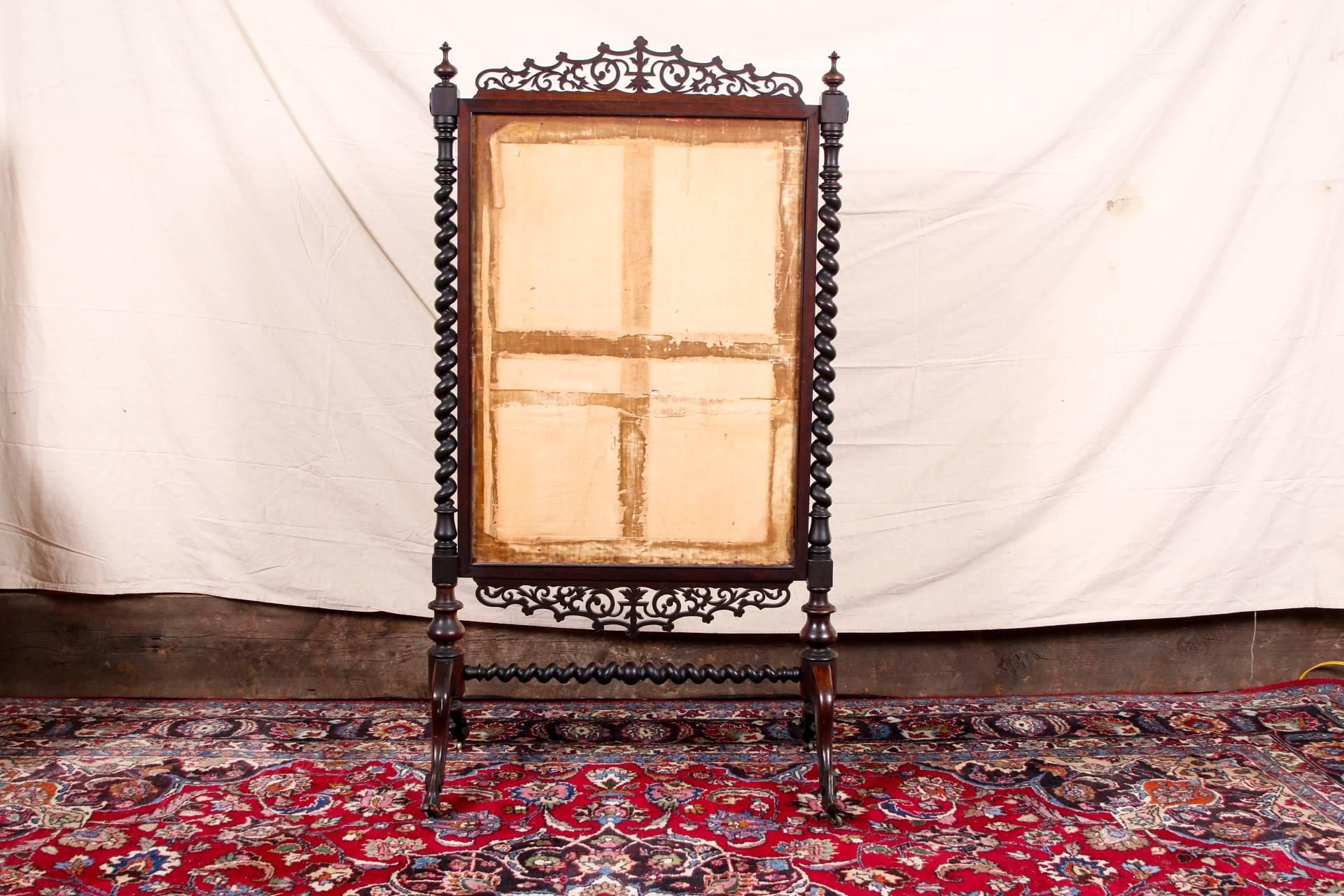 Antique fire screen, rosewood frame with needlepoint screen, carved openwork crest rail and lower frame, barley twist supports with rosette tops and finials, mounted on carved scrolled feet with a barley twist stretcher, fine floral needlepoint