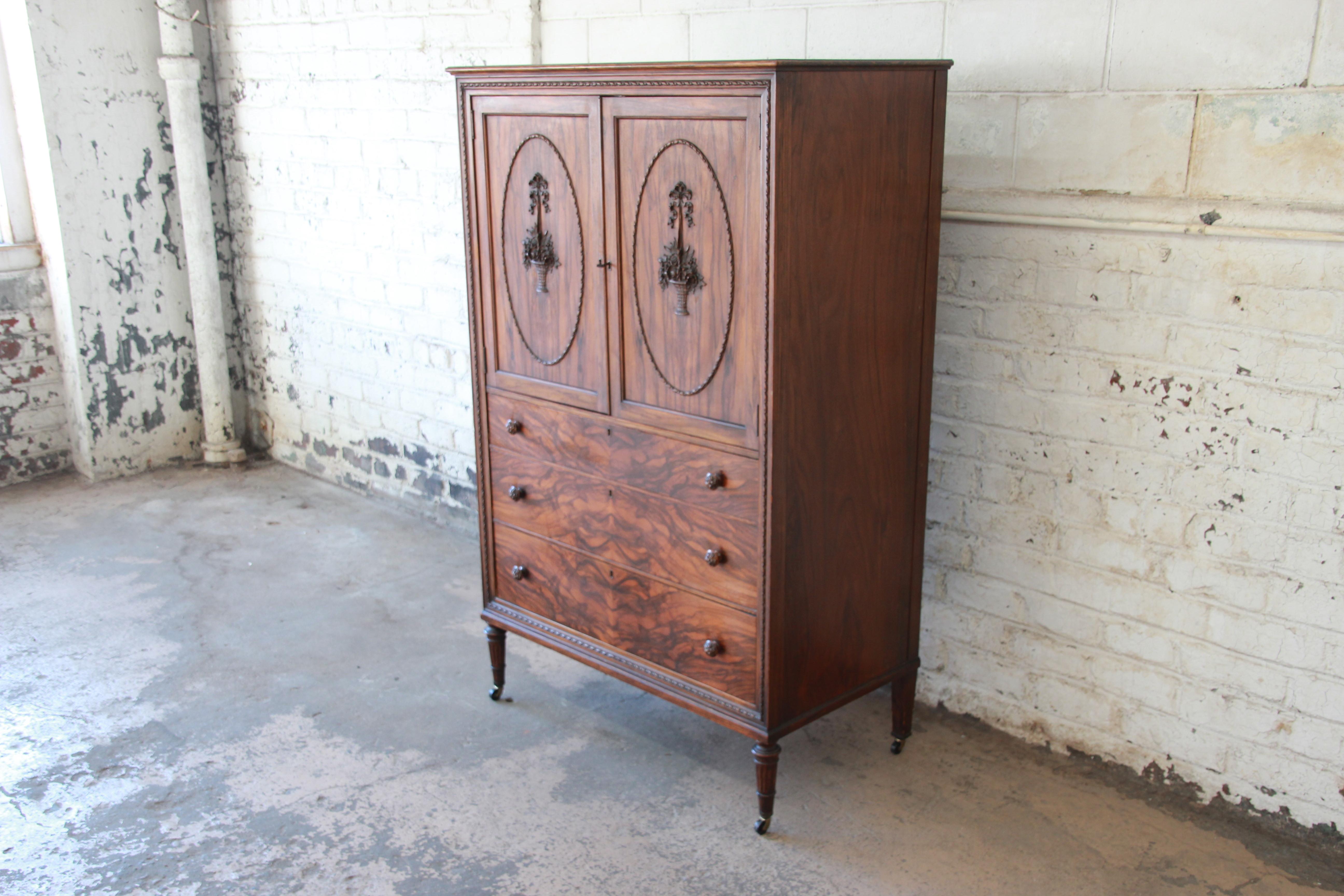 Offering a stunning antique rosewood French carved Chifferobe dresser or armoire. The piece has two large cabinet doors with carved fruit basket details that open up to four large drawers for storage. Each drawer has a nice rosewood grain and offers